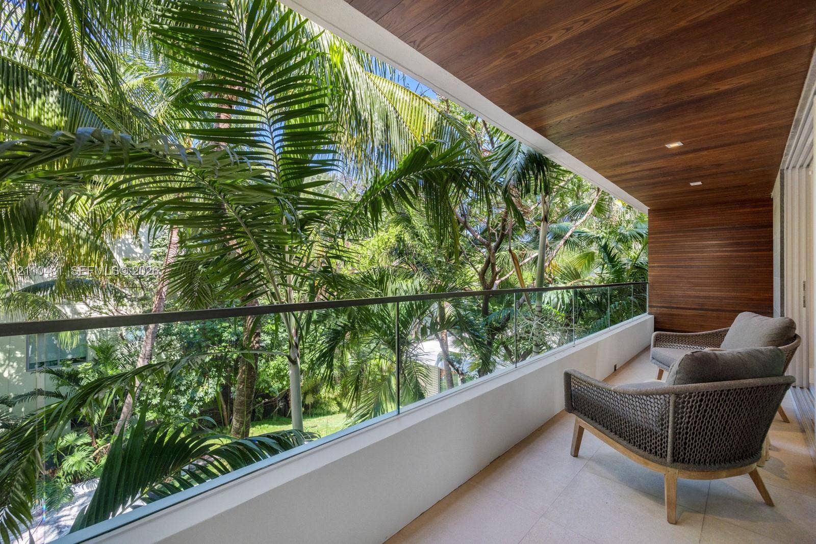 234 Washington Avenue, #D, Miami Beach, FL 33139 Covered balcony featuring wood-paneled ceiling, glass panel railing, and stone tile flooring