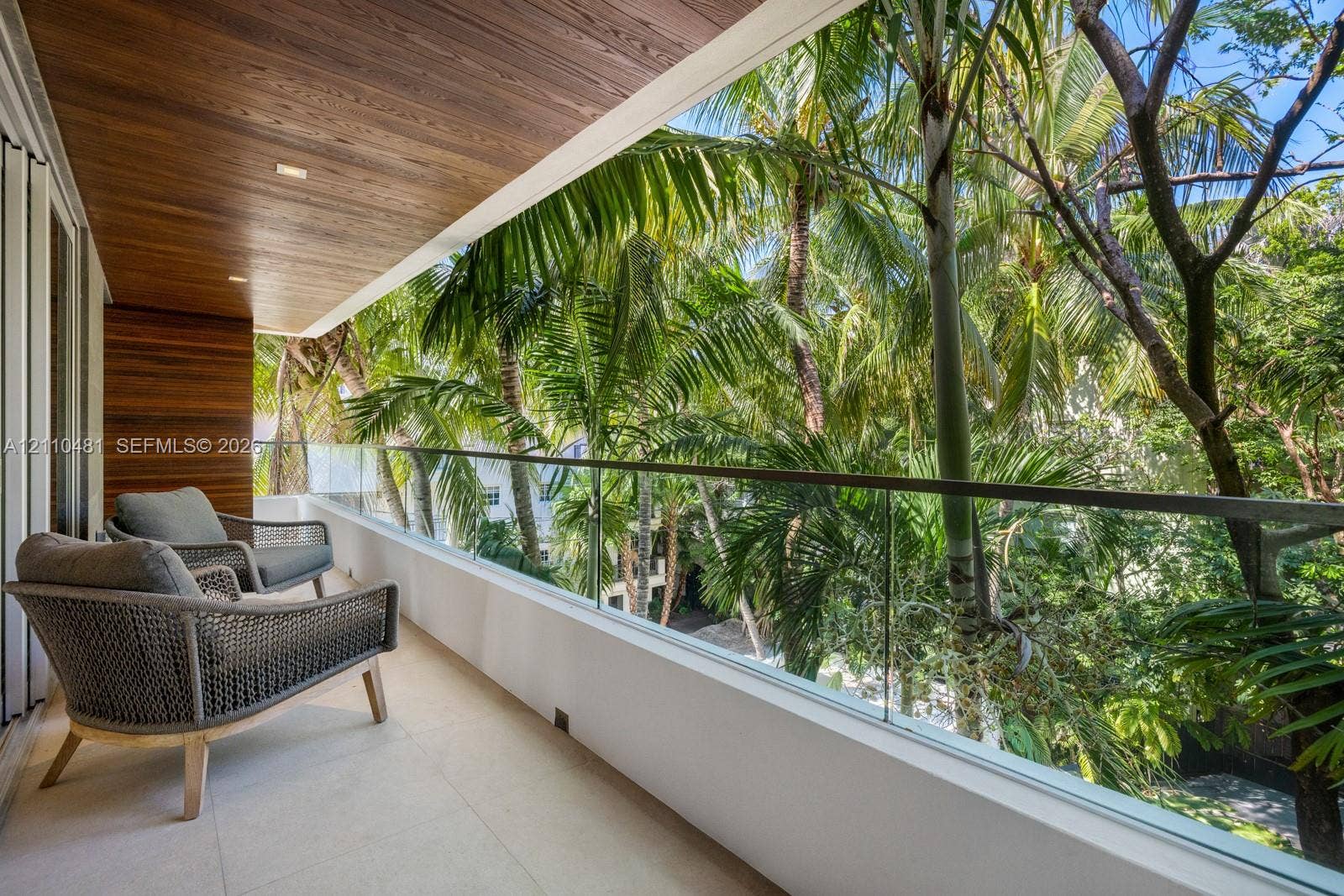234 Washington Avenue, #D, Miami Beach, FL 33139 Covered balcony featuring wood-plank ceiling paneling, frameless glass railing, and light-toned tile flooring