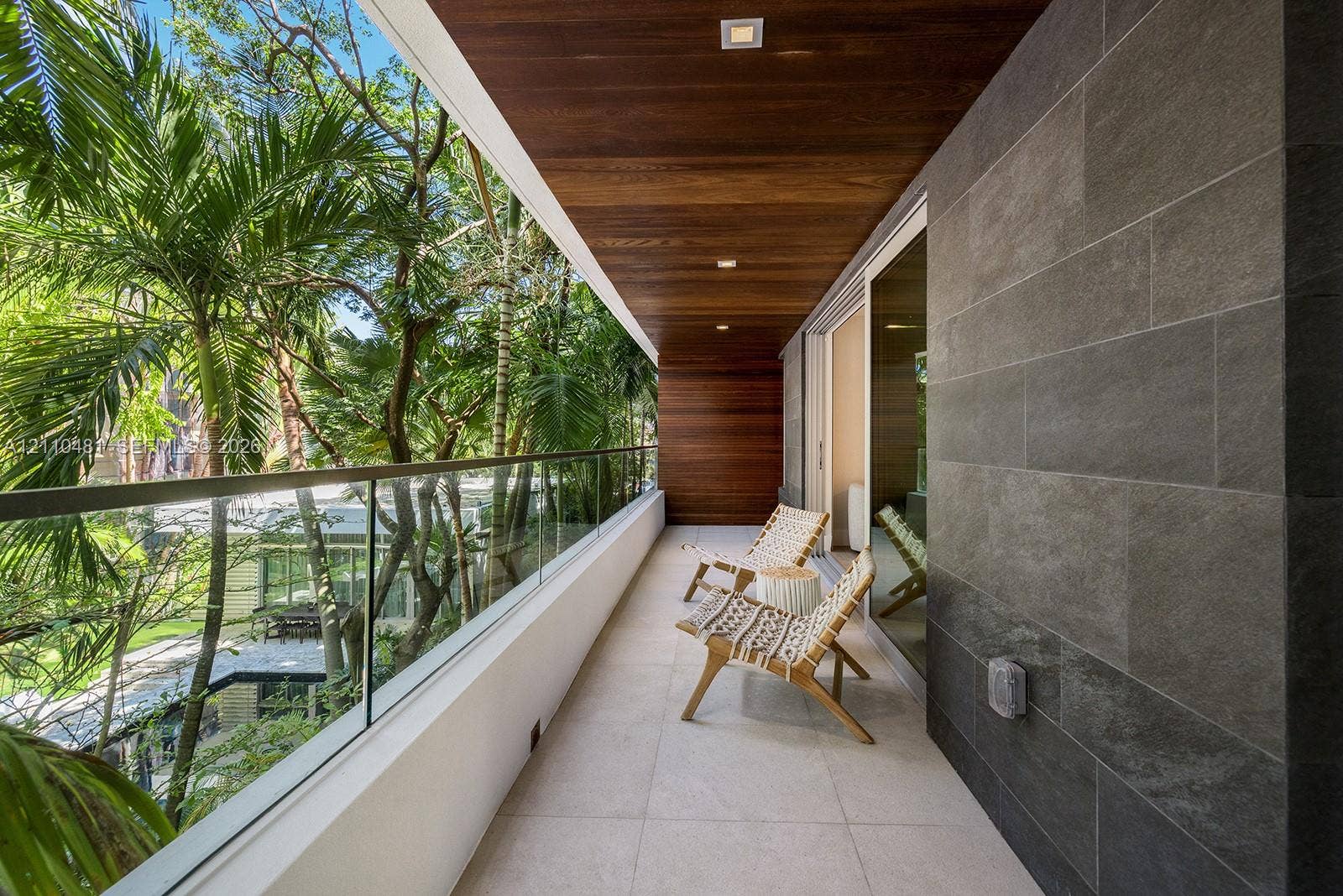 234 Washington Avenue, #D, Miami Beach, FL 33139 Covered balcony featuring wood-plank ceiling, recessed lighting, large-format tile flooring, a glass panel railing, and charcoal-toned stone wall cladding