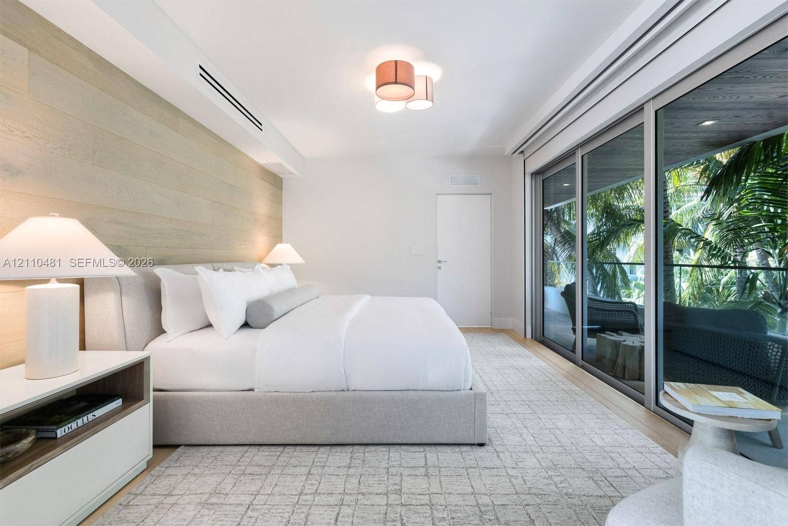 234 Washington Avenue, #D, Miami Beach, FL 33139 Wood-finish wall paneling, floor-to-ceiling sliding glass doors, recessed lighting, and flush-mount ceiling fixture
