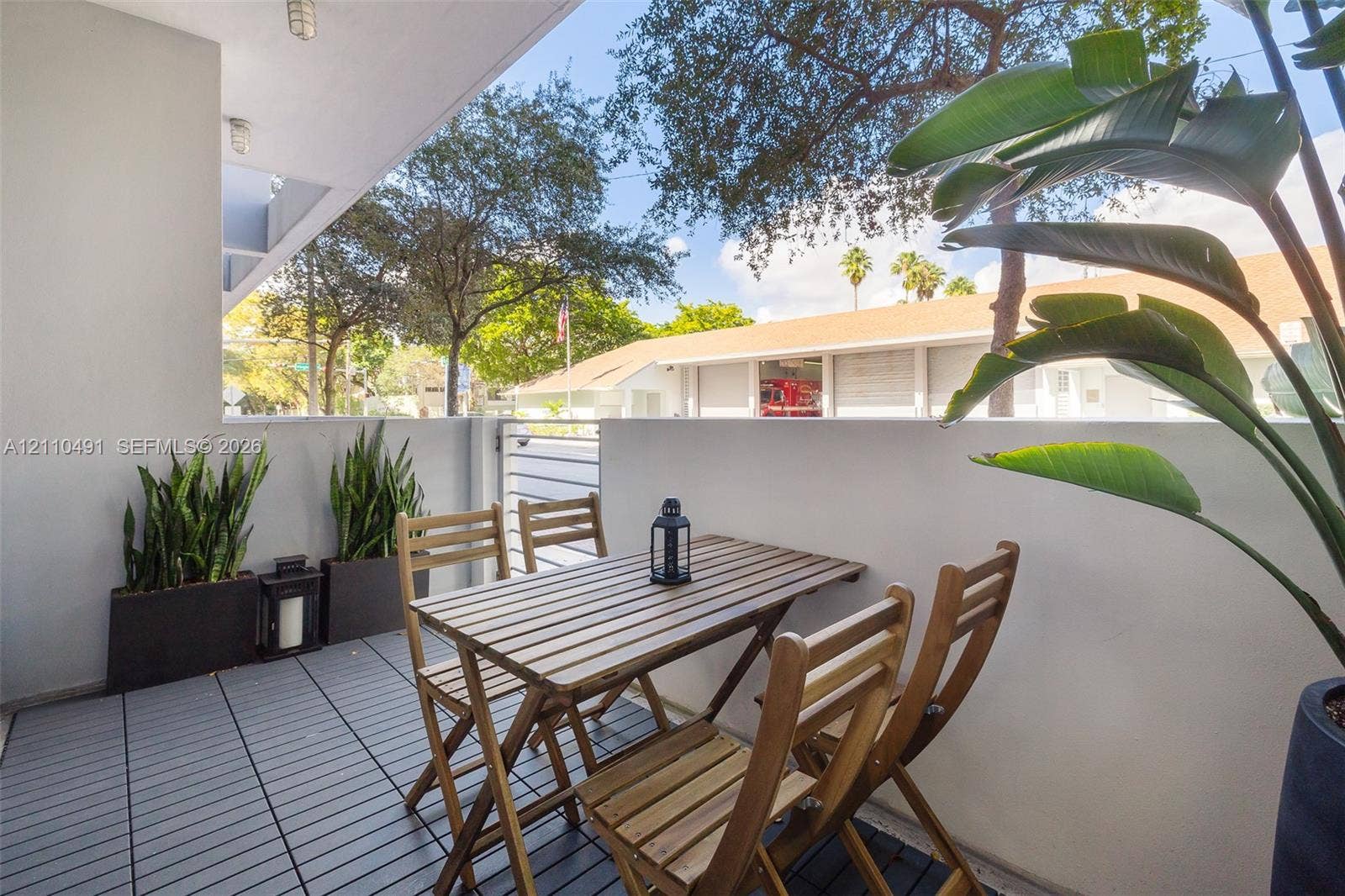 3339 Virginia Street, #136, Miami, Miami, FL 33133 Covered balcony featuring grey composite decking, solid masonry privacy walls, and flush-mount ceiling lighting