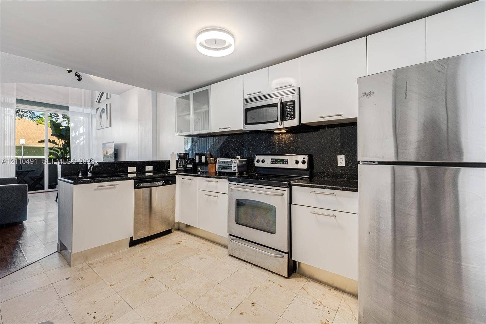 3339 Virginia Street, #136, Miami, Miami, FL 33133 Kitchen featuring flat-panel white cabinetry, stone-finish countertops, stainless steel appliances, and tile flooring