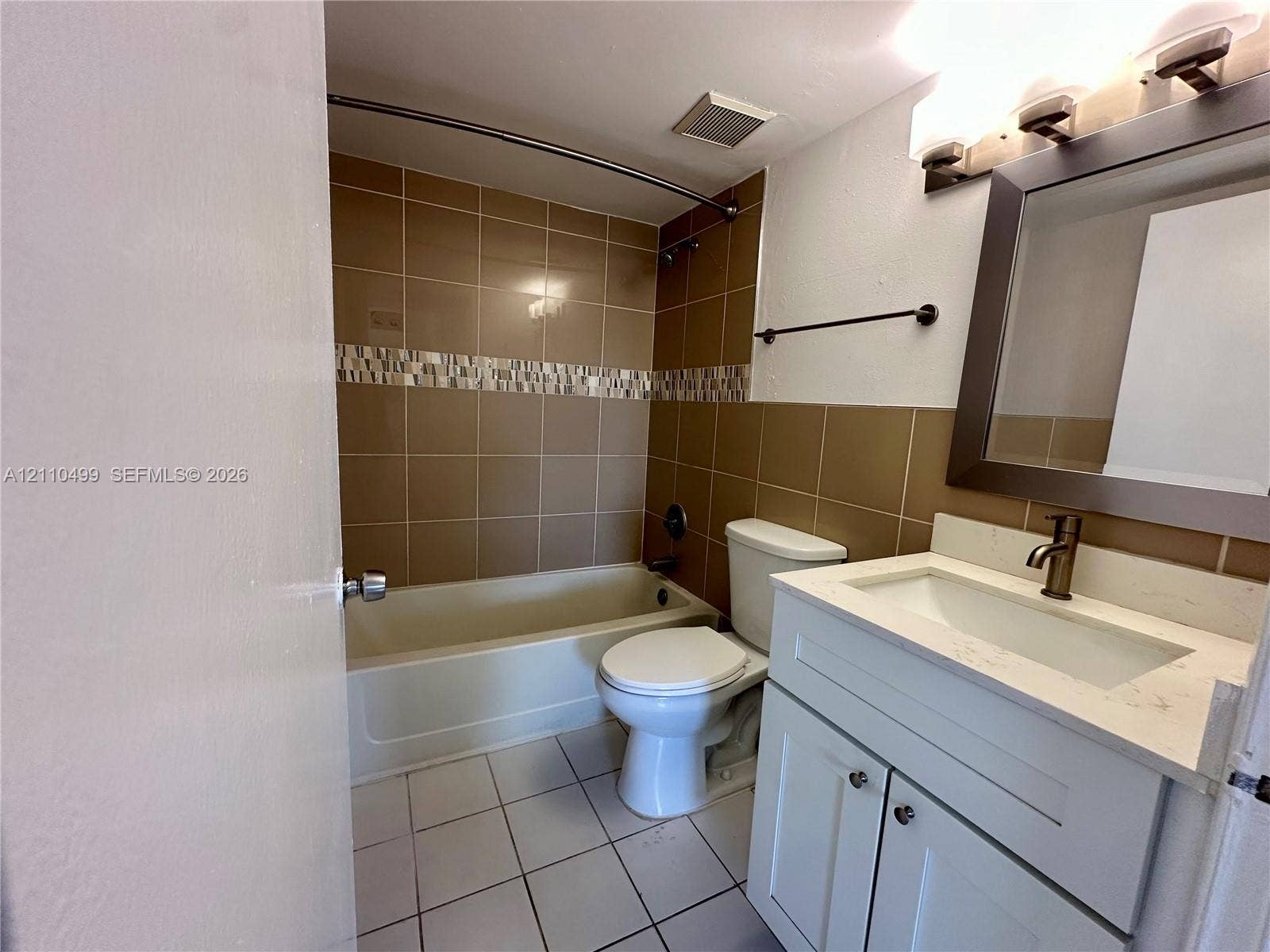 8145 NW 7th Street, #308, Miami, Miami, FL 33126 Bathroom featuring a vanity with a light-toned countertop, integrated basin, and bronze-finish hardware