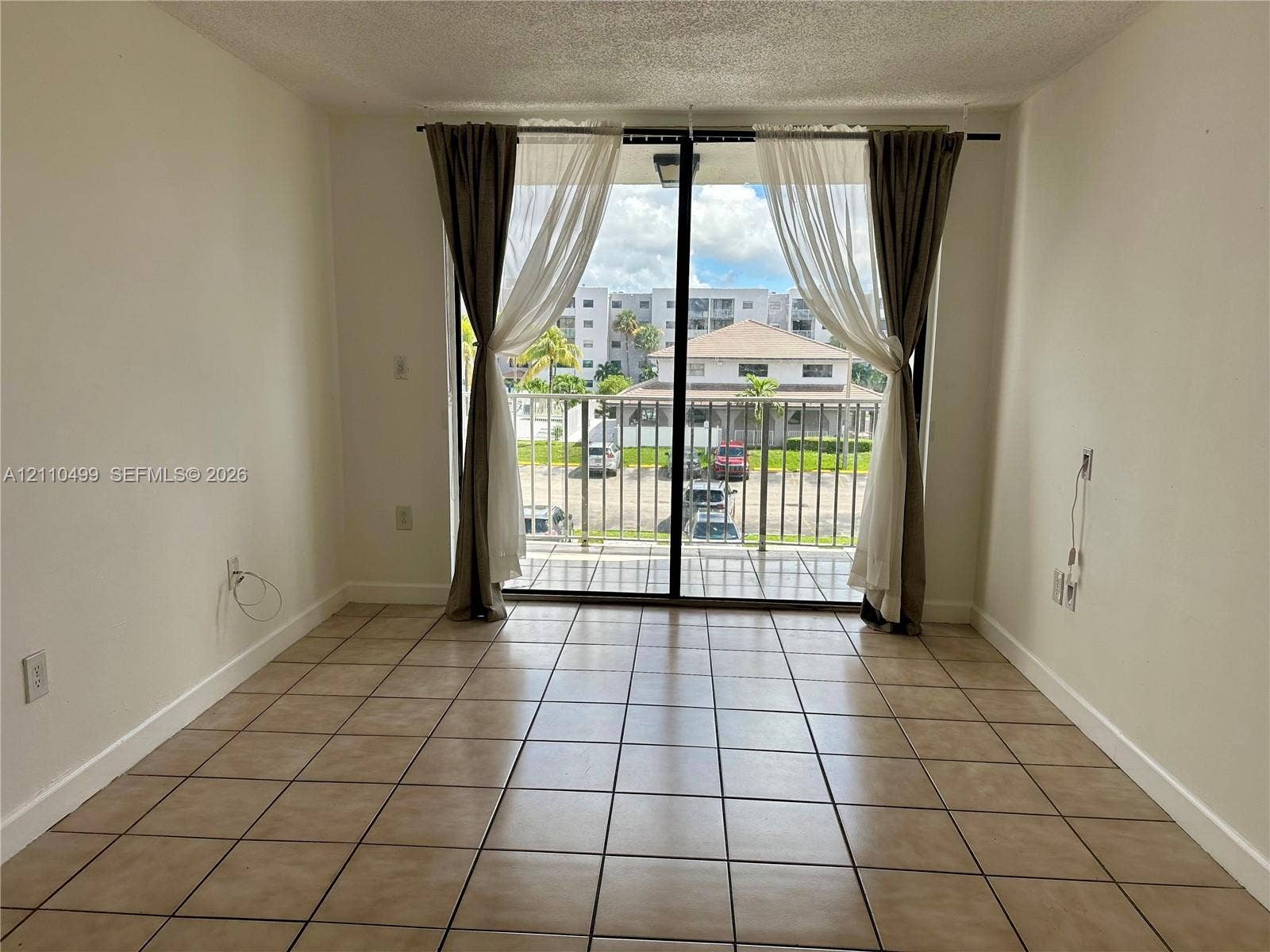 8145 NW 7th Street, #308, Miami, Miami, FL 33126 Ceramic tile flooring, sliding glass door, and covered balcony with metal railing
