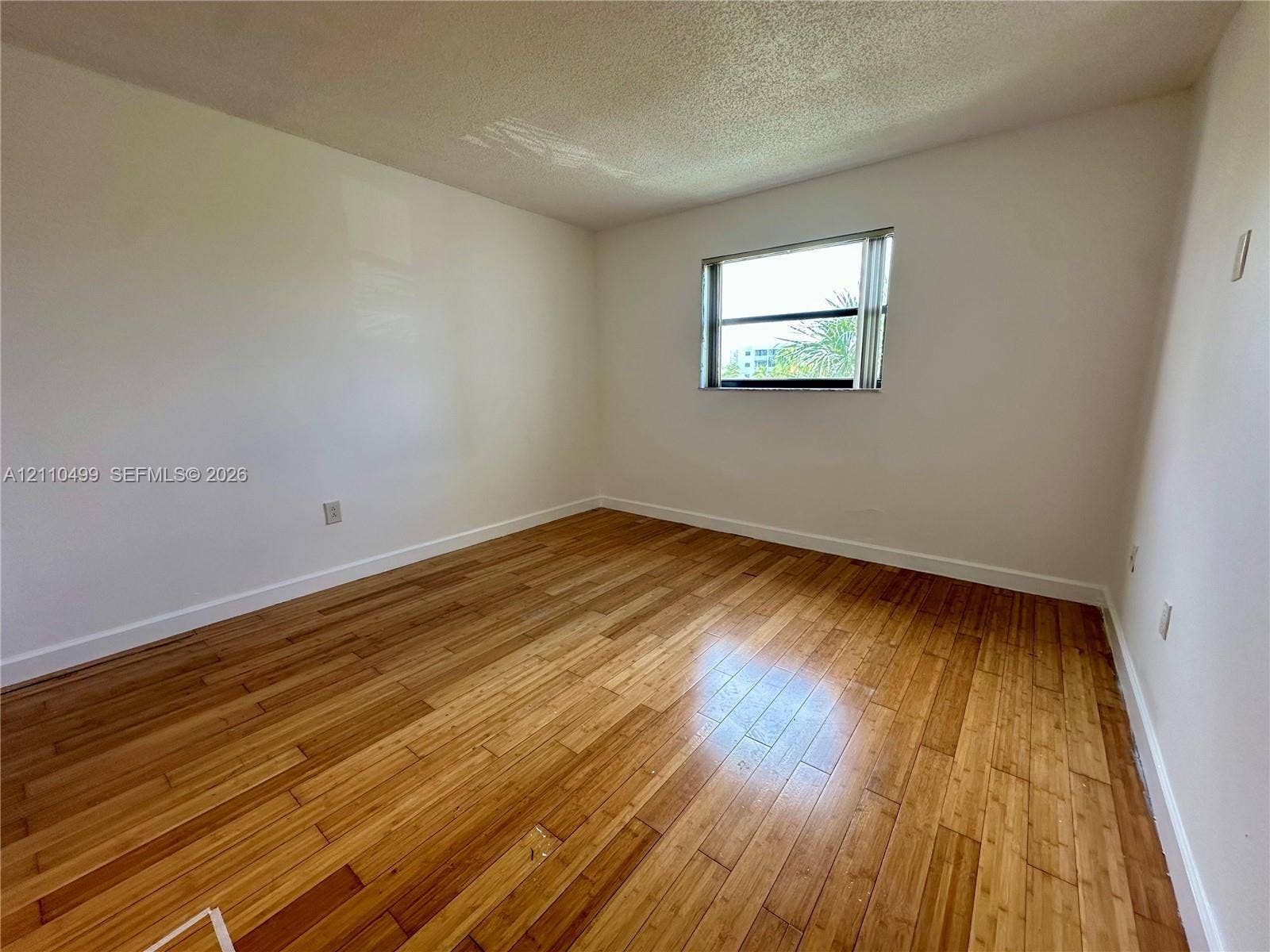 8145 NW 7th Street, #308, Miami, Miami, FL 33126 Room featuring wood-finish flooring and a single-pane sliding window