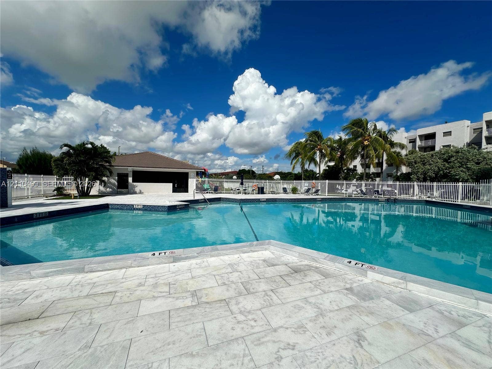 8145 NW 7th Street, #308, Miami, Miami, FL 33126 Swimming pool featuring tile surround, paved decking, and perimeter fencing