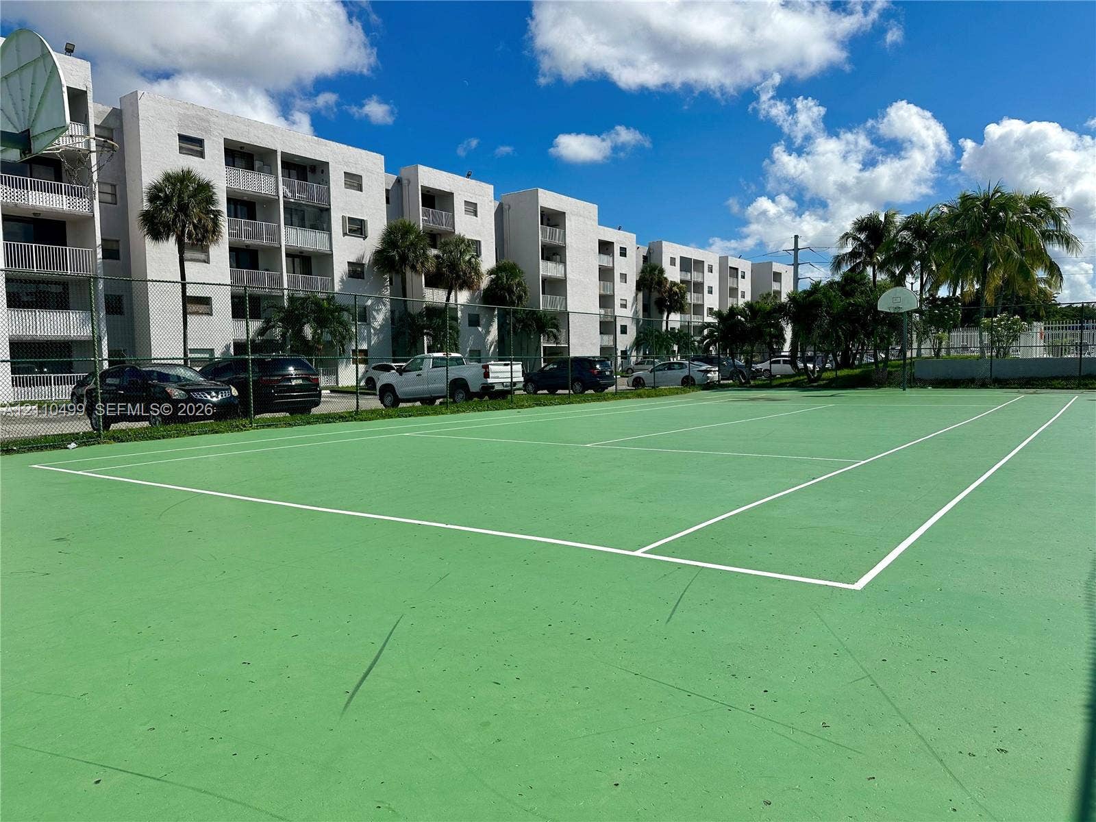 8145 NW 7th Street, #308, Miami, Miami, FL 33126 Tennis court featuring a hard surface, perimeter fencing, and an integrated basketball hoop