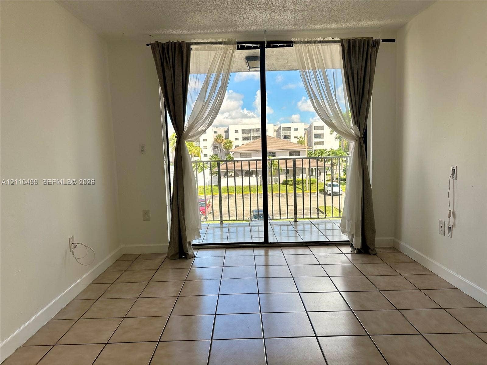 8145 NW 7th Street, #308, Miami, Miami, FL 33126 Floor-to-ceiling sliding glass doors opening to a private balcony with metal railing and tile flooring