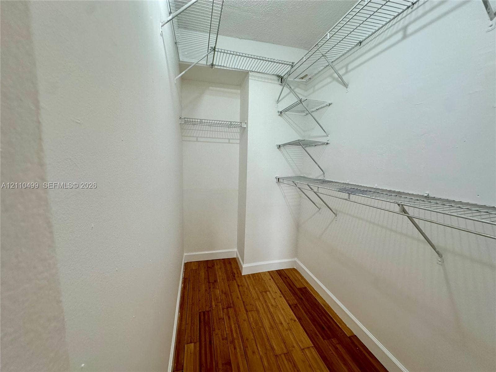 8145 NW 7th Street, #308, Miami, Miami, FL 33126 Walk-in closet featuring wood-finish flooring and tiered metal wire shelving