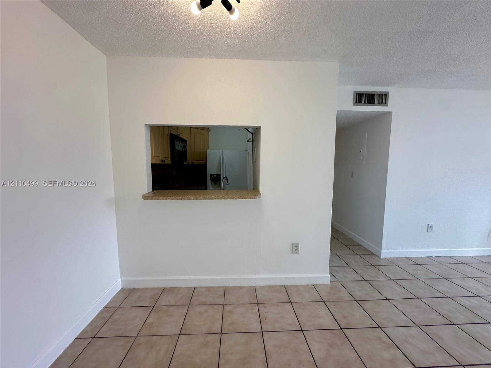8145 NW 7th Street, #308, Miami, Miami, FL 33126 Ceramic tile flooring, interior pass-through window with a countertop ledge, and textured ceiling finish