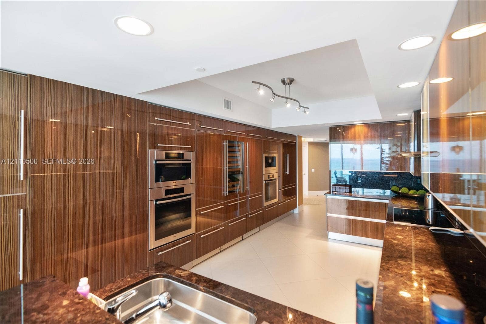 2711 S Ocean Drive, #2205, Hollywood, Hollywood, FL 33019 Modern kitchen featuring high-gloss wood-finish cabinetry, stone countertops, stainless steel wall ovens, a built-in wine cooler, and recessed lighting