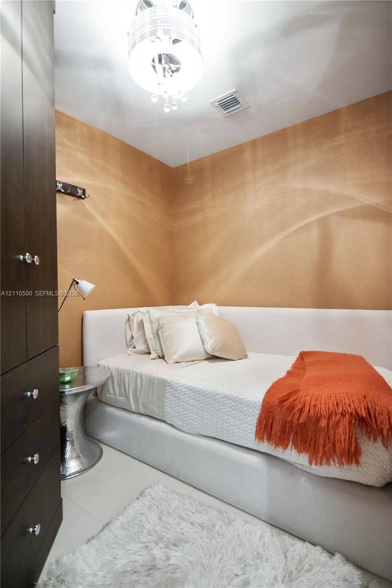 2711 S Ocean Drive, #2205, Hollywood, Hollywood, FL 33019 Floor-to-ceiling dark wood-finish cabinetry, textured amber wall treatment, and decorative ceiling pendant light