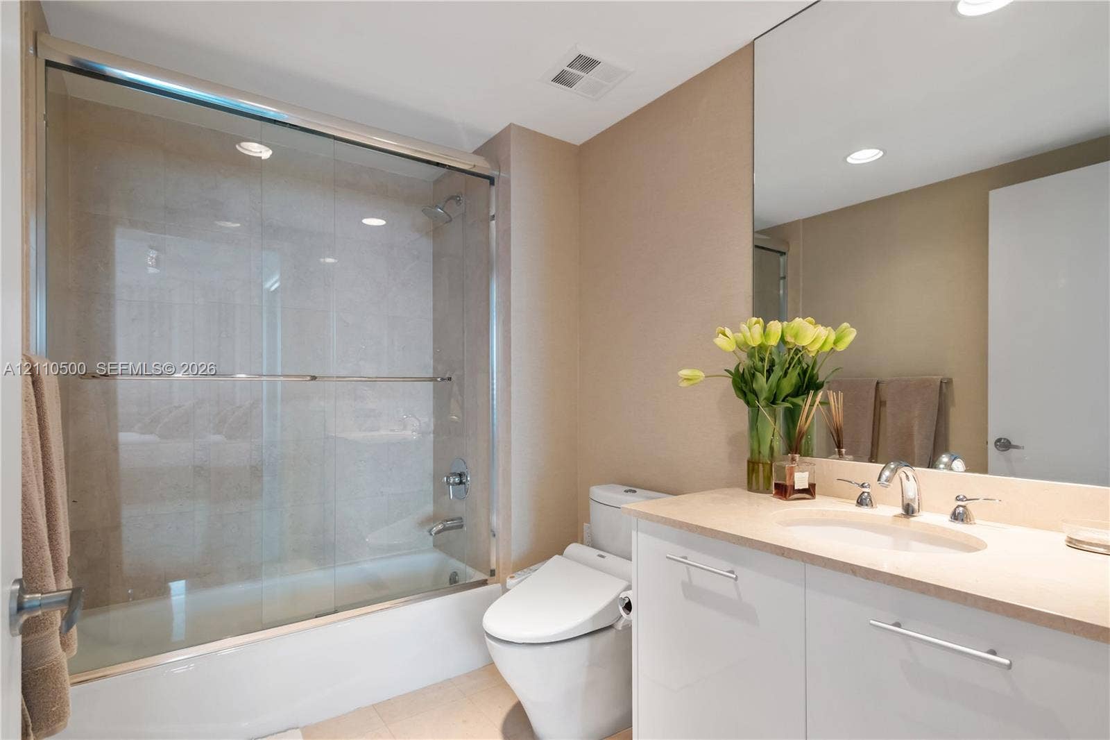 2711 S Ocean Drive, #2205, Hollywood, Hollywood, FL 33019 Bathroom featuring a tub-shower combination with glass enclosure, white vanity with stone-surfaced countertop, integrated oval basin, and a large wall-mounted mirror
