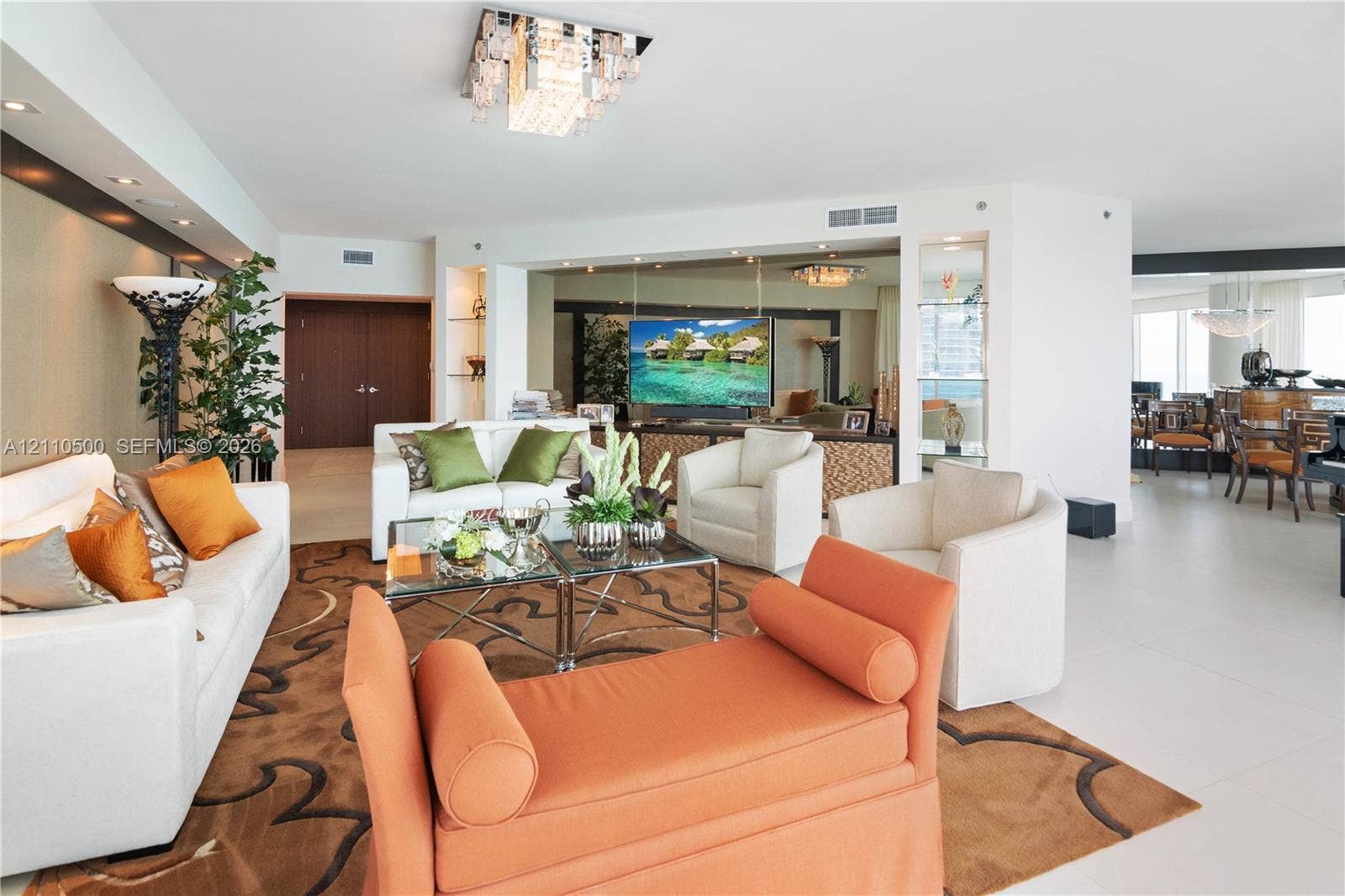 2711 S Ocean Drive, #2205, Hollywood, Hollywood, FL 33019 Open-concept living space featuring large-format tile flooring, built-in recessed wall shelving, mirrored accent walls, and a multi-tiered crystal flush-mount light fixture