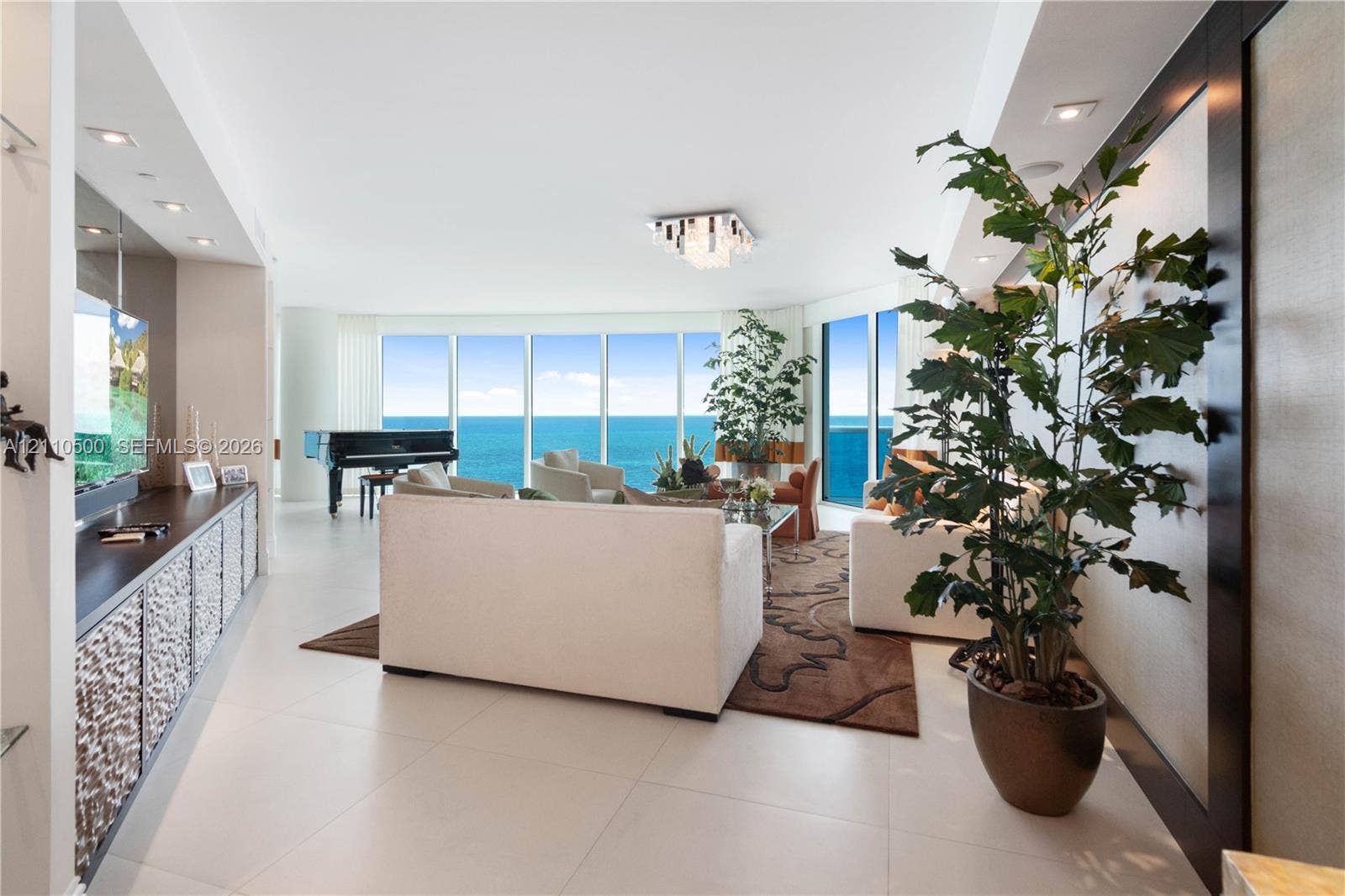 2711 S Ocean Drive, #2205, Hollywood, Hollywood, FL 33019 Floor-to-ceiling windows, large-format tile flooring, recessed ceiling lighting, built-in cabinetry with textured paneling, and a geometric chandelier