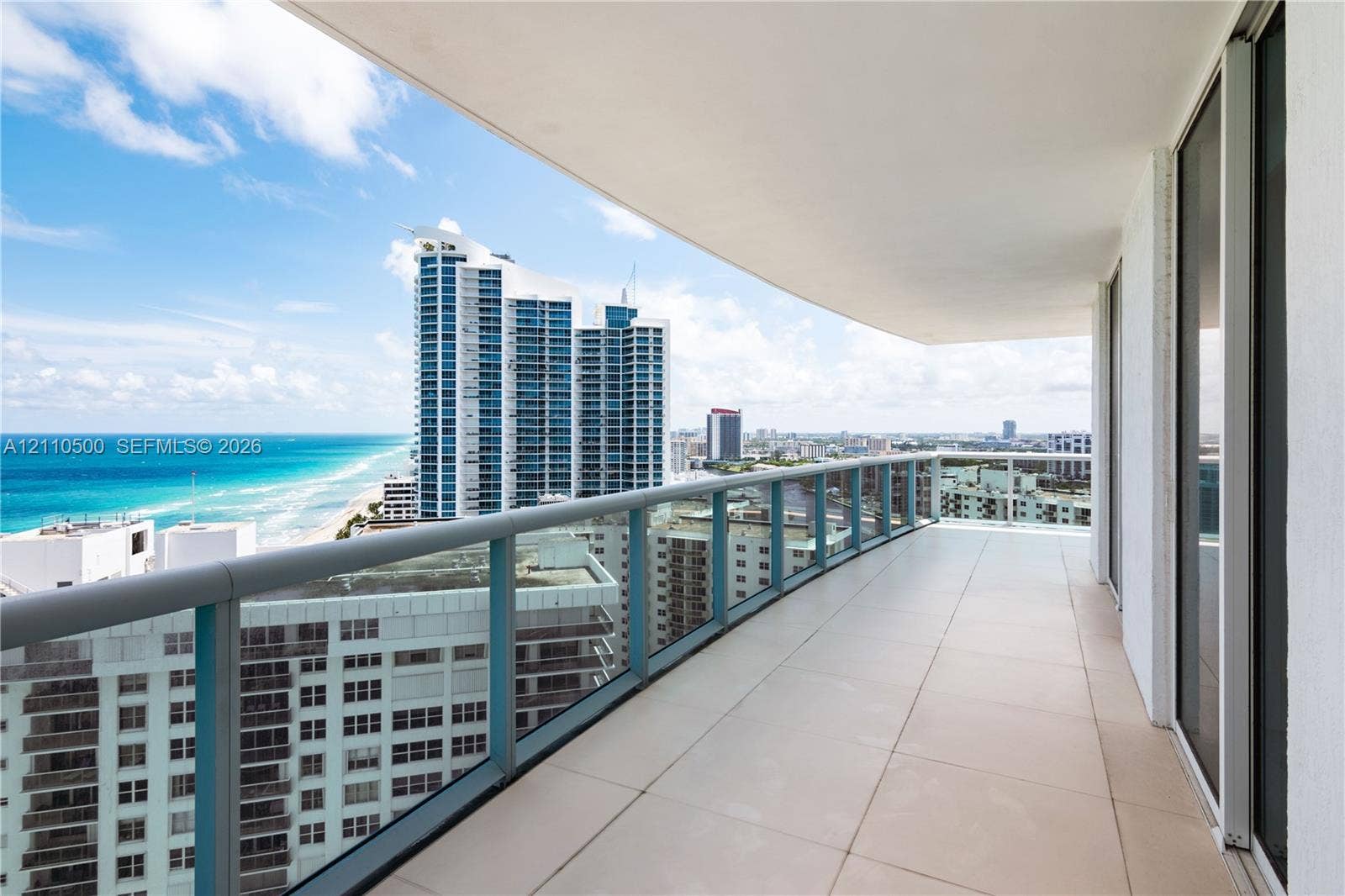2711 S Ocean Drive, #2205, Hollywood, Hollywood, FL 33019 Expansive balcony featuring large-format tile flooring, a glass-panel railing, and panoramic coastal and urban scenery