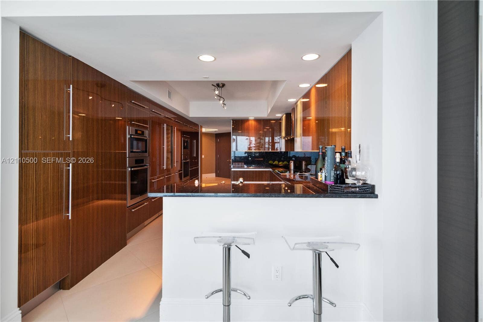 2711 S Ocean Drive, #2205, Hollywood, Hollywood, FL 33019 High-gloss wood-finish cabinetry, built-in stainless steel double wall ovens, dark stone countertop, and recessed ceiling lighting