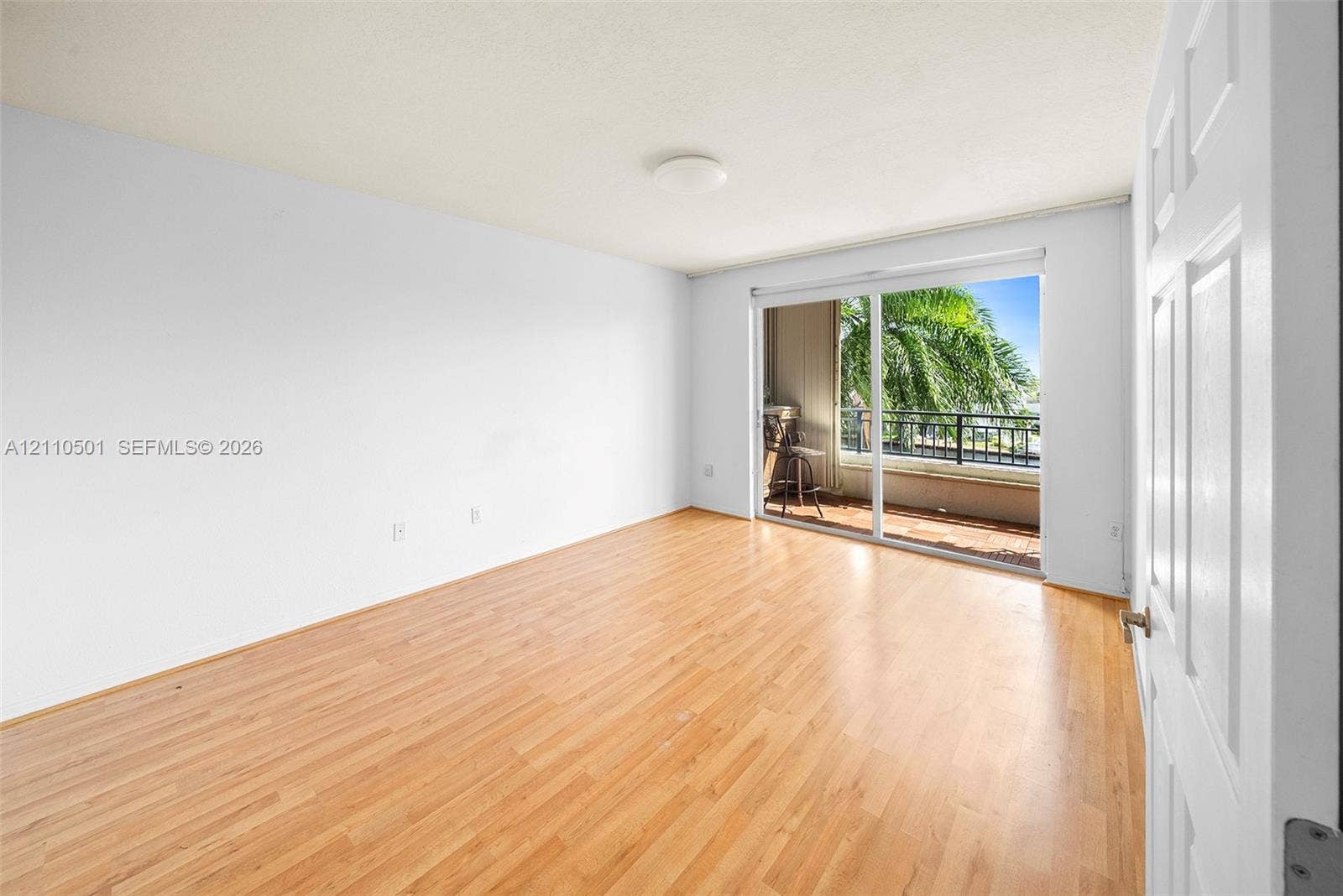 Primary Bedroom featuring wood-finish flooring, sliding glass doors, and a private balcony