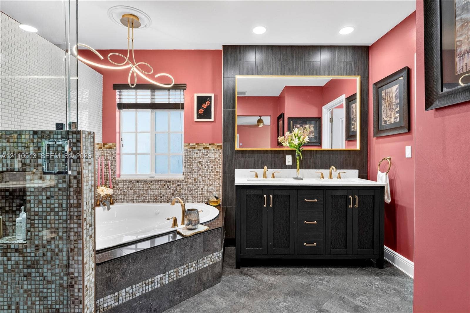 6520 SW 16th Terrace, West Miami, FL 33155 Dual-sink vanity with dark cabinetry, gold-tone hardware, and an oversized rectangular wall mirror