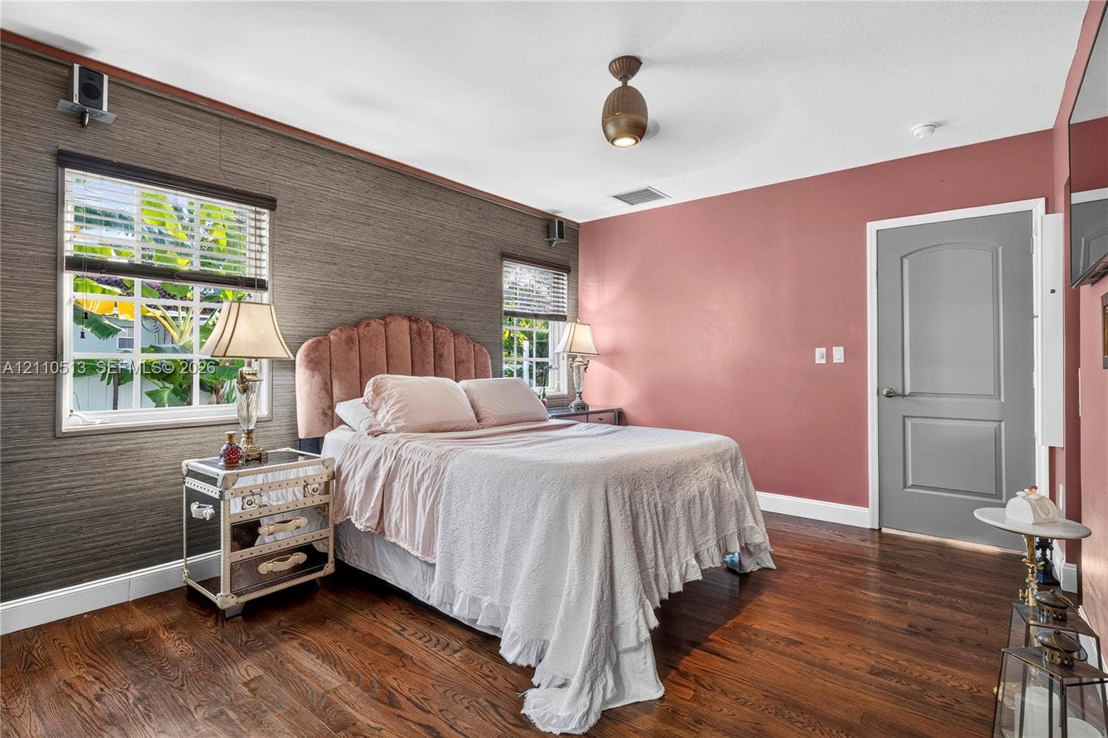 6520 SW 16th Terrace, West Miami, FL 33155 Room featuring wood-finish flooring, dual windows with blinds, a textured accent wall, and a contemporary ceiling-mounted light fixture