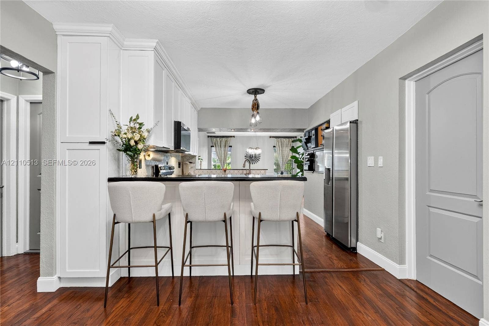 6520 SW 16th Terrace, West Miami, FL 33155 Kitchen featuring white cabinetry, dark countertops, wood-finish flooring, stainless steel refrigerator, and recessed ceiling lighting