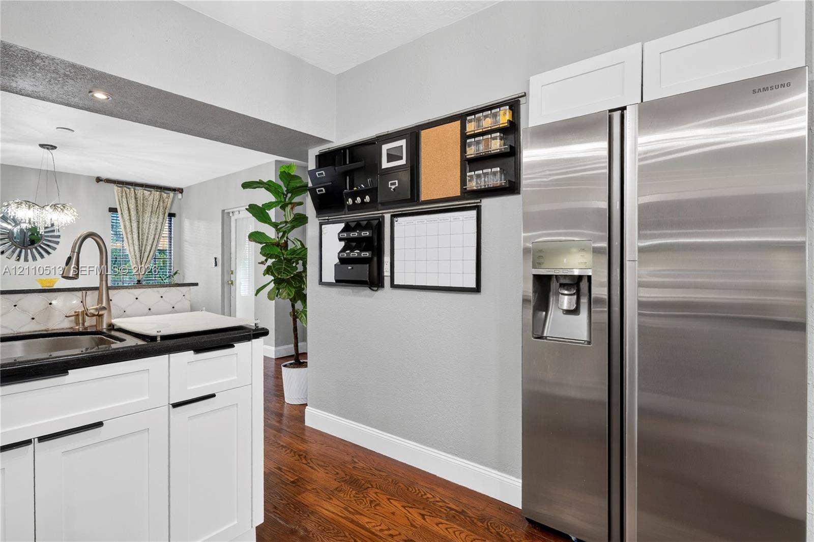 6520 SW 16th Terrace, West Miami, FL 33155 Kitchen featuring white shaker-style cabinetry, stainless steel refrigerator, dark stone-finish countertops, and wood-finish flooring