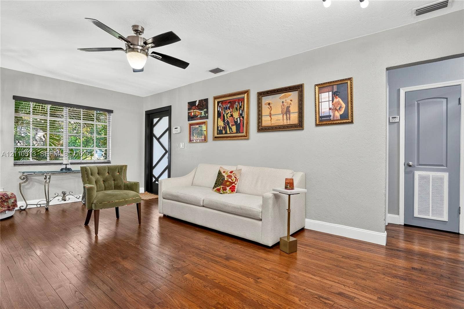 6520 SW 16th Terrace, West Miami, FL 33155 Living area featuring wood-finish flooring, a multi-pane glass entry door, and a central ceiling fan