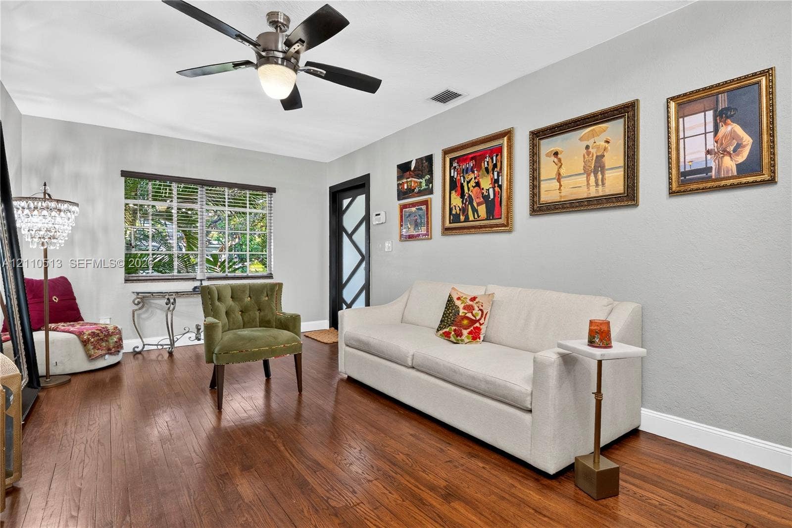 6520 SW 16th Terrace, West Miami, FL 33155 Living area featuring wood-finish flooring, a multi-blade ceiling fan with integrated lighting, and a front entry door with a geometric pane design