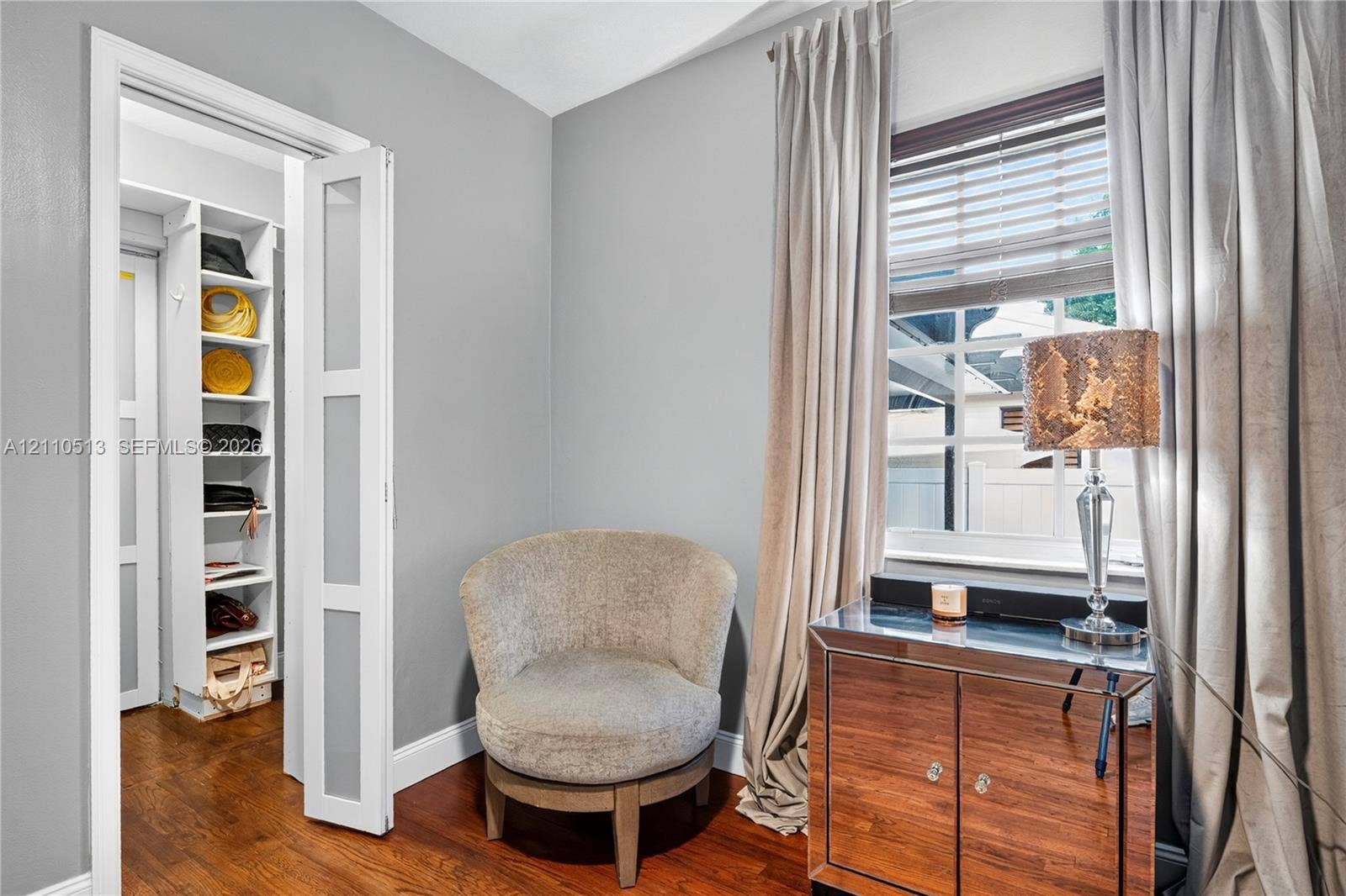 6520 SW 16th Terrace, West Miami, FL 33155 Wood-finish flooring, white framed multi-panel door, and custom built-in shelving unit