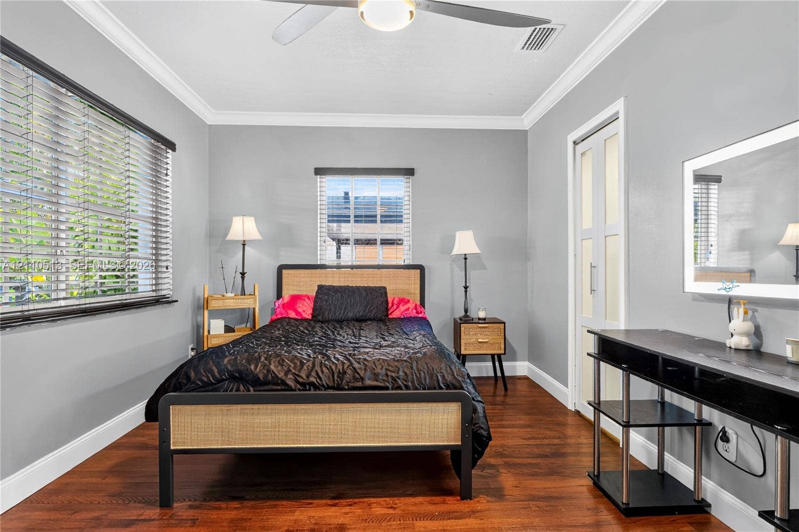 6520 SW 16th Terrace, West Miami, FL 33155 Room featuring wood-finish flooring, crown molding, dual-pane windows with horizontal blinds, and a ceiling fan with integrated lighting