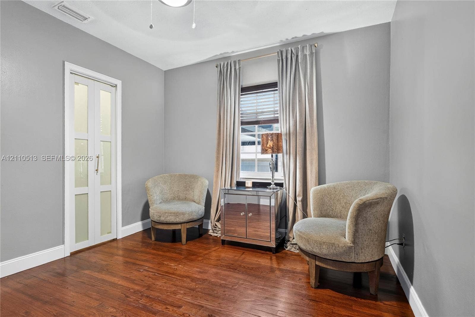 6520 SW 16th Terrace, West Miami, FL 33155 Interior space featuring wood-finish flooring, neutral wall paint, and a bi-fold door with frosted glass panes