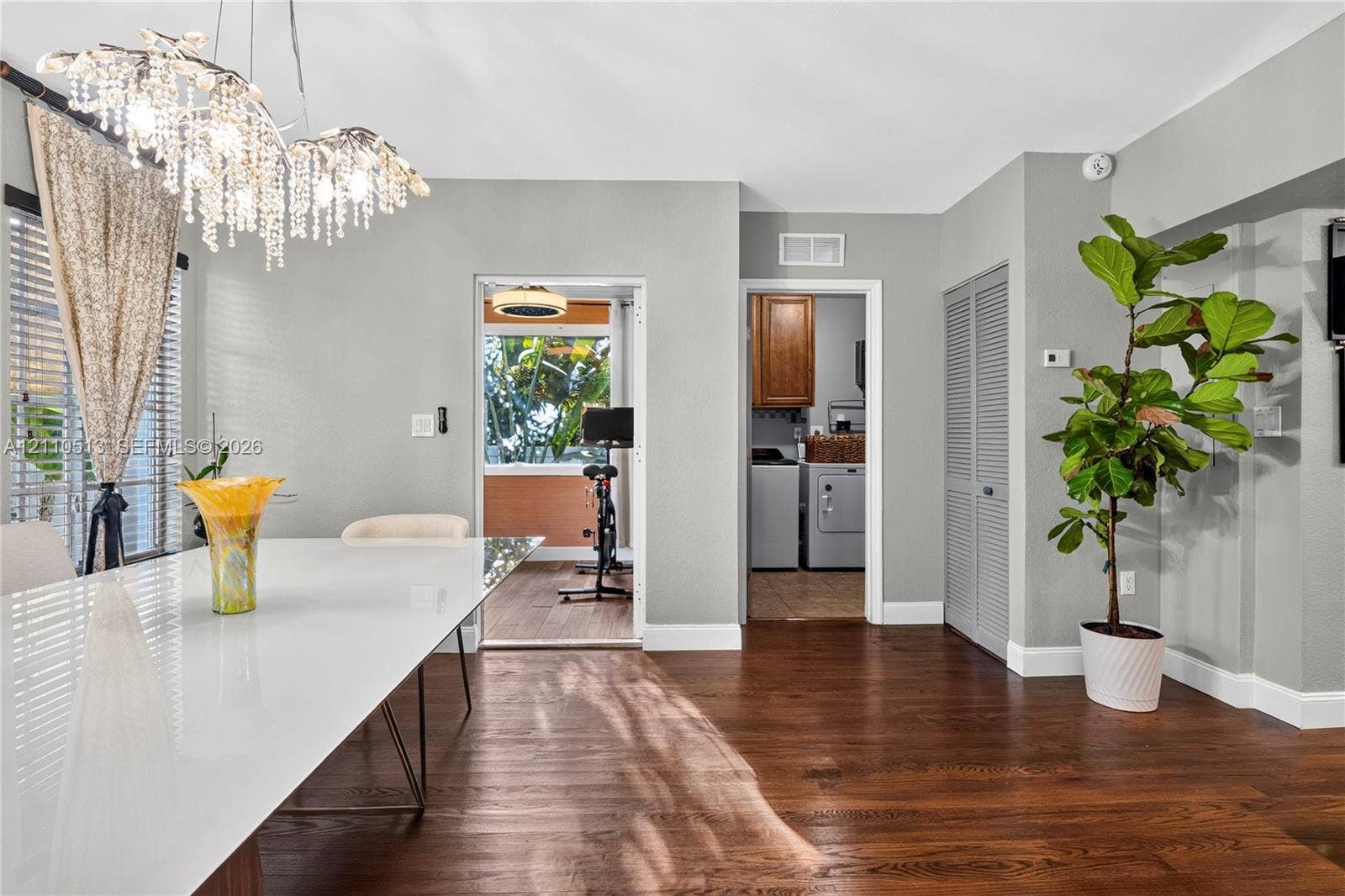 6520 SW 16th Terrace, West Miami, FL 33155 Wood-finish flooring, decorative crystal chandelier, and louvered closet doors