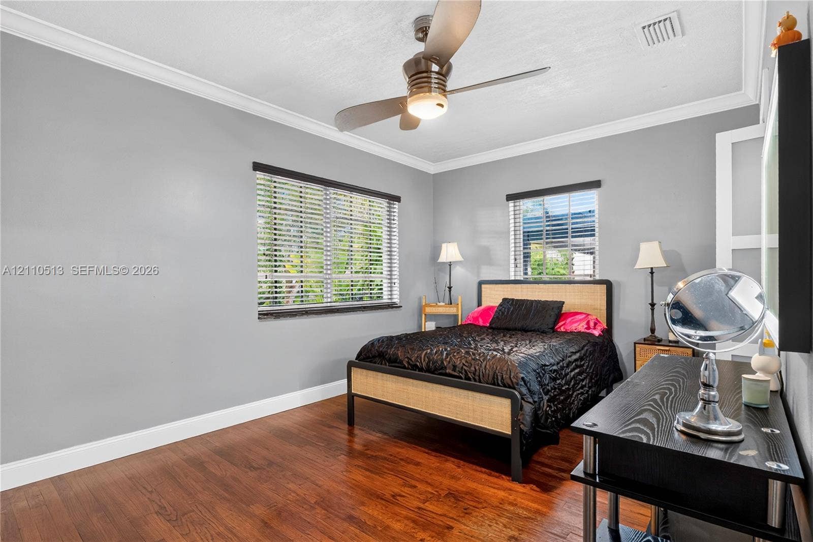 6520 SW 16th Terrace, West Miami, FL 33155 Room featuring wood-finish flooring, crown molding, dual windows with horizontal blinds, and a ceiling fan with integrated lighting