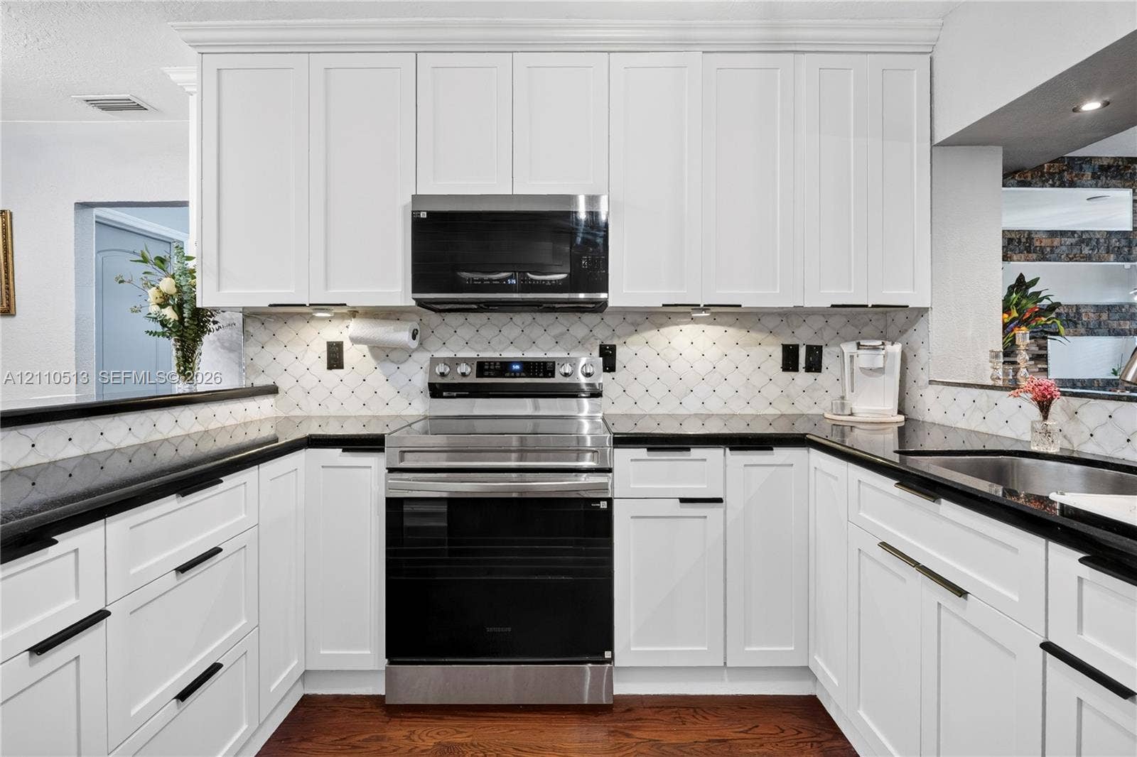 6520 SW 16th Terrace, West Miami, FL 33155 Kitchen featuring white shaker-style cabinetry, stainless steel appliances, dark stone countertops, decorative tile backsplash, and wood-finish flooring