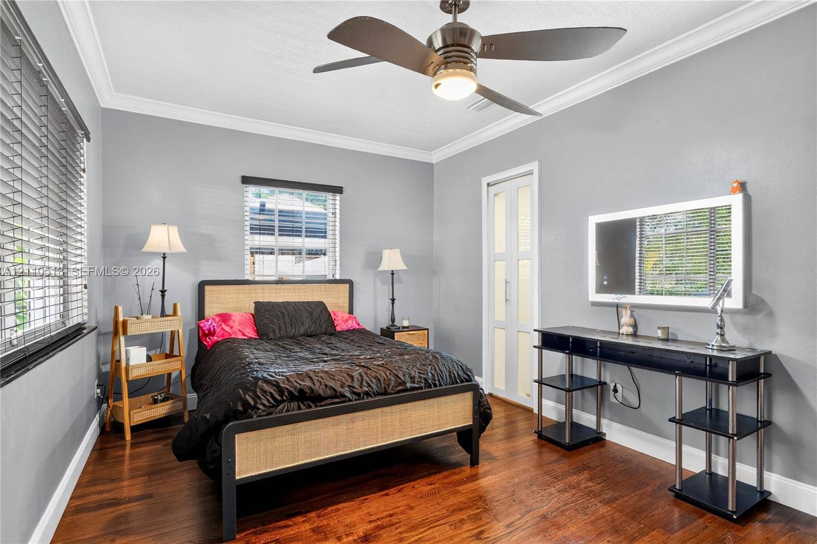 6520 SW 16th Terrace, West Miami, FL 33155 Bedroom featuring wood-finish flooring, crown molding, a multi-blade ceiling fan with integrated lighting, horizontal window blinds, and a multi-panel door