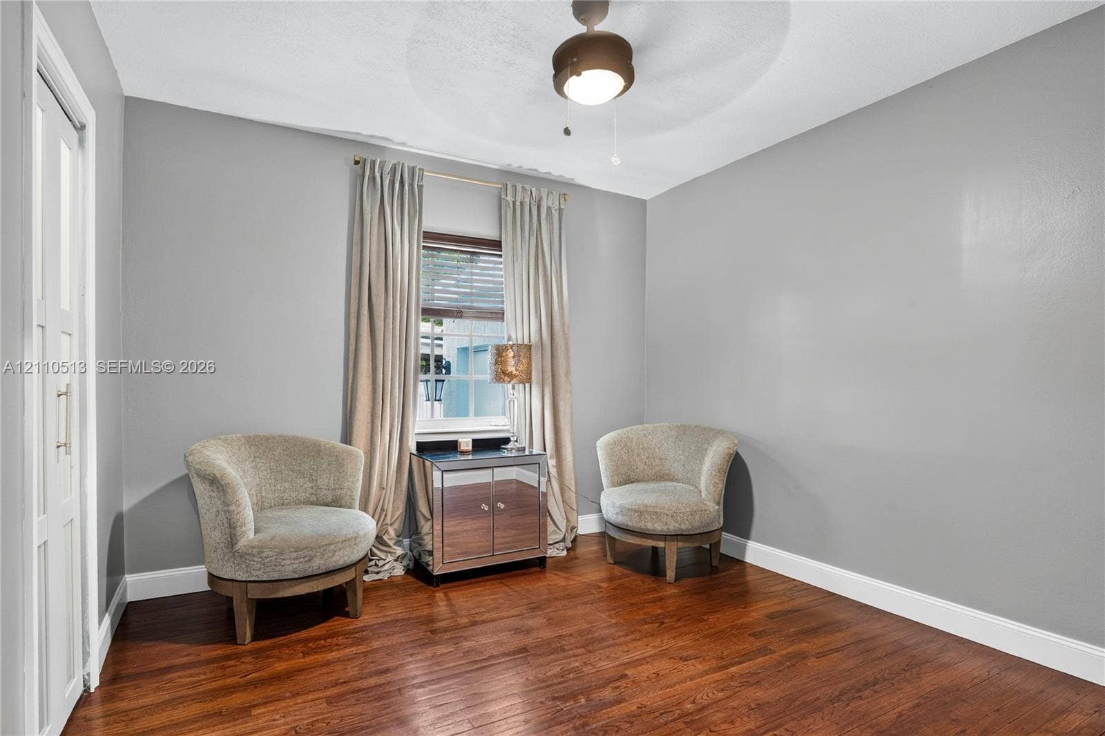6520 SW 16th Terrace, West Miami, FL 33155 Room featuring wood-finish flooring, a central ceiling fan with an integrated light fixture, and a window with white trim