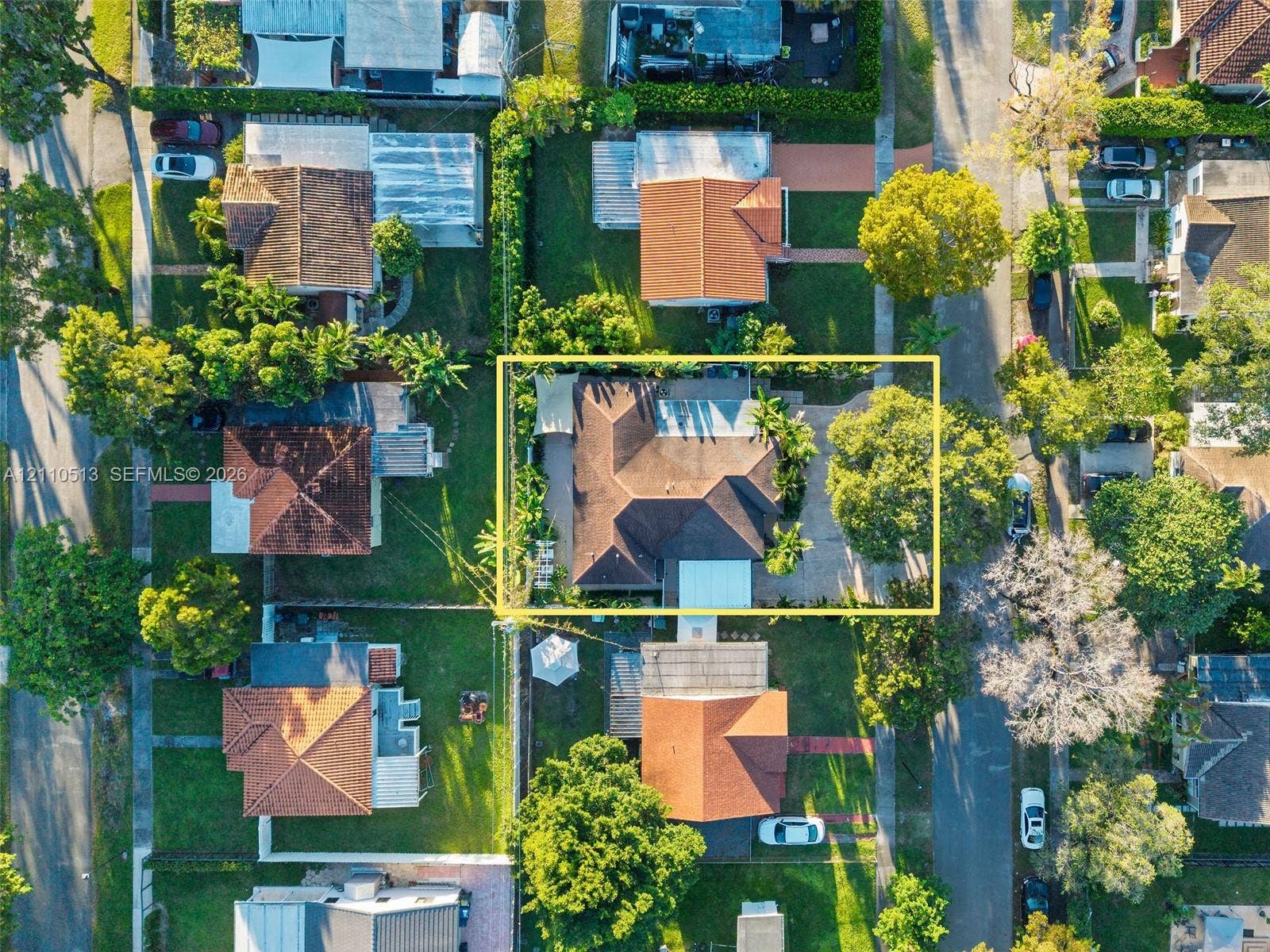 6520 SW 16th Terrace, West Miami, FL 33155 Aerial perspective of a property featuring a multi-pitched roof, concrete driveway, established trees, and perimeter landscaping within a residential neighborhood