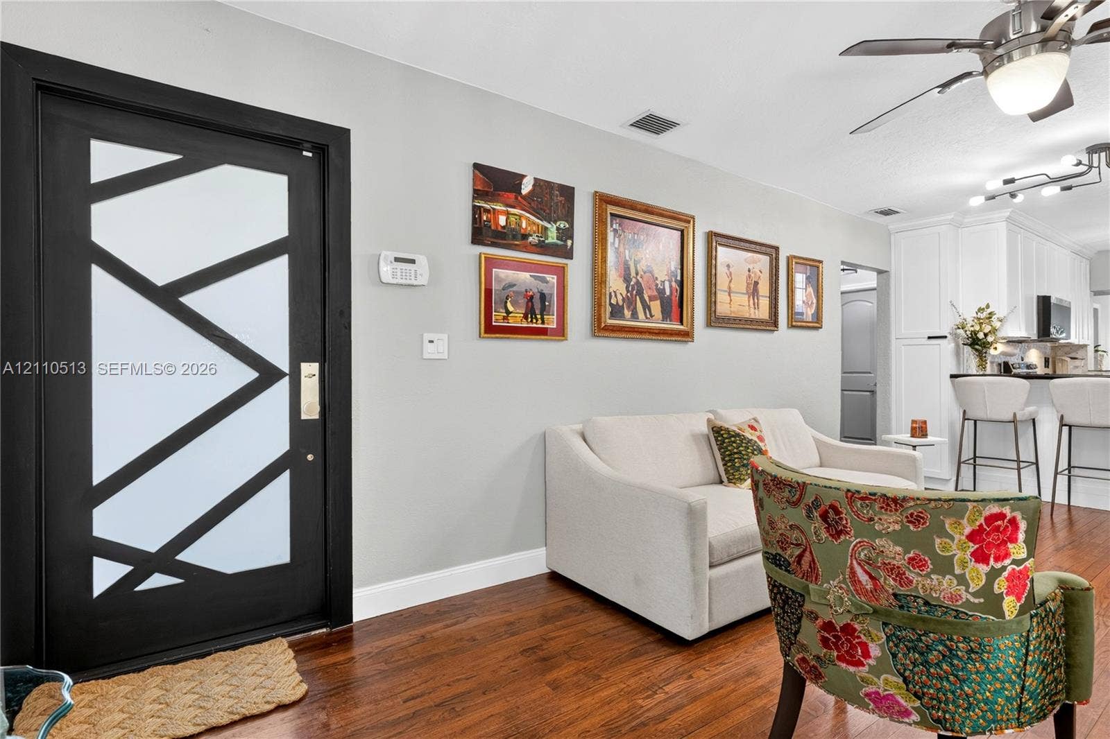 6520 SW 16th Terrace, West Miami, FL 33155 Modern front door with geometric black trim and frosted glass panels, wood-finish flooring, and ceiling fan with integrated lighting