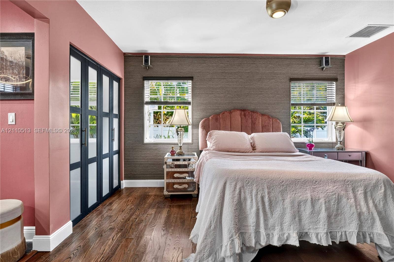 6520 SW 16th Terrace, West Miami, FL 33155 Wood-finish flooring, textured wall covering, double-hung windows, and floor-to-ceiling built-in closet with multi-pane glass doors