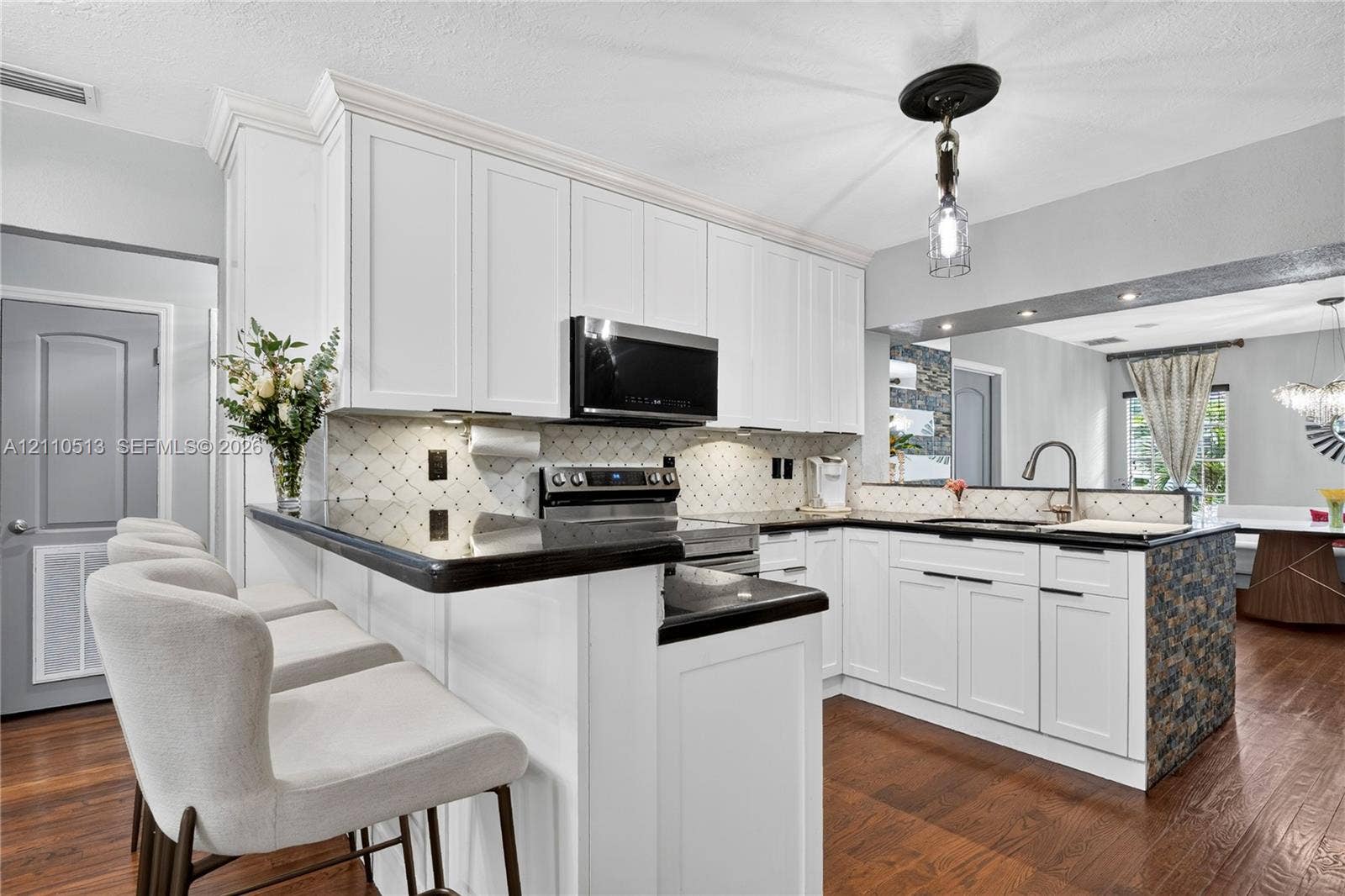 6520 SW 16th Terrace, West Miami, FL 33155 Kitchen featuring white shaker-style cabinetry, dark stone countertops, stainless steel appliances, decorative tiled backsplash, and wood-finish flooring