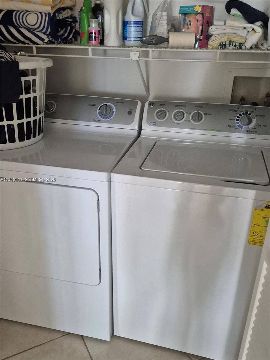 Laundry area featuring side-by-side appliances and wire shelving