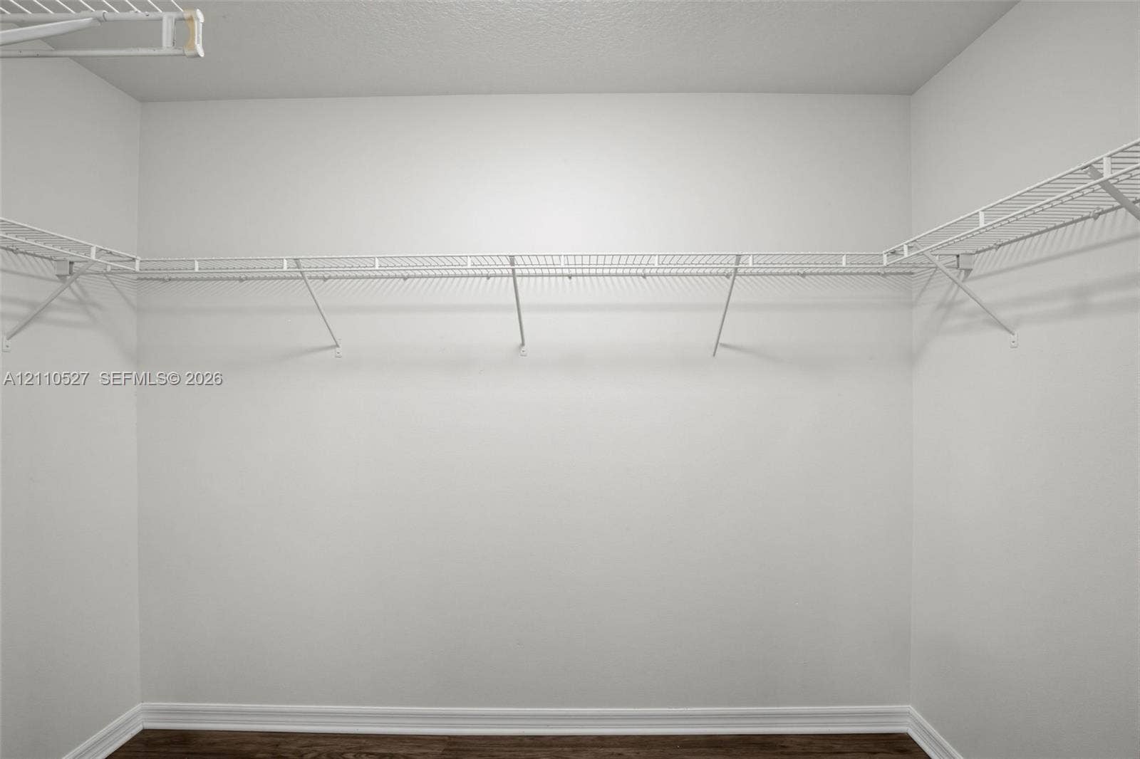 5509 NW Commodore Terrace, Port St Lucie, FL 34983 Walk-in closet featuring white wire shelving and wood-finish flooring