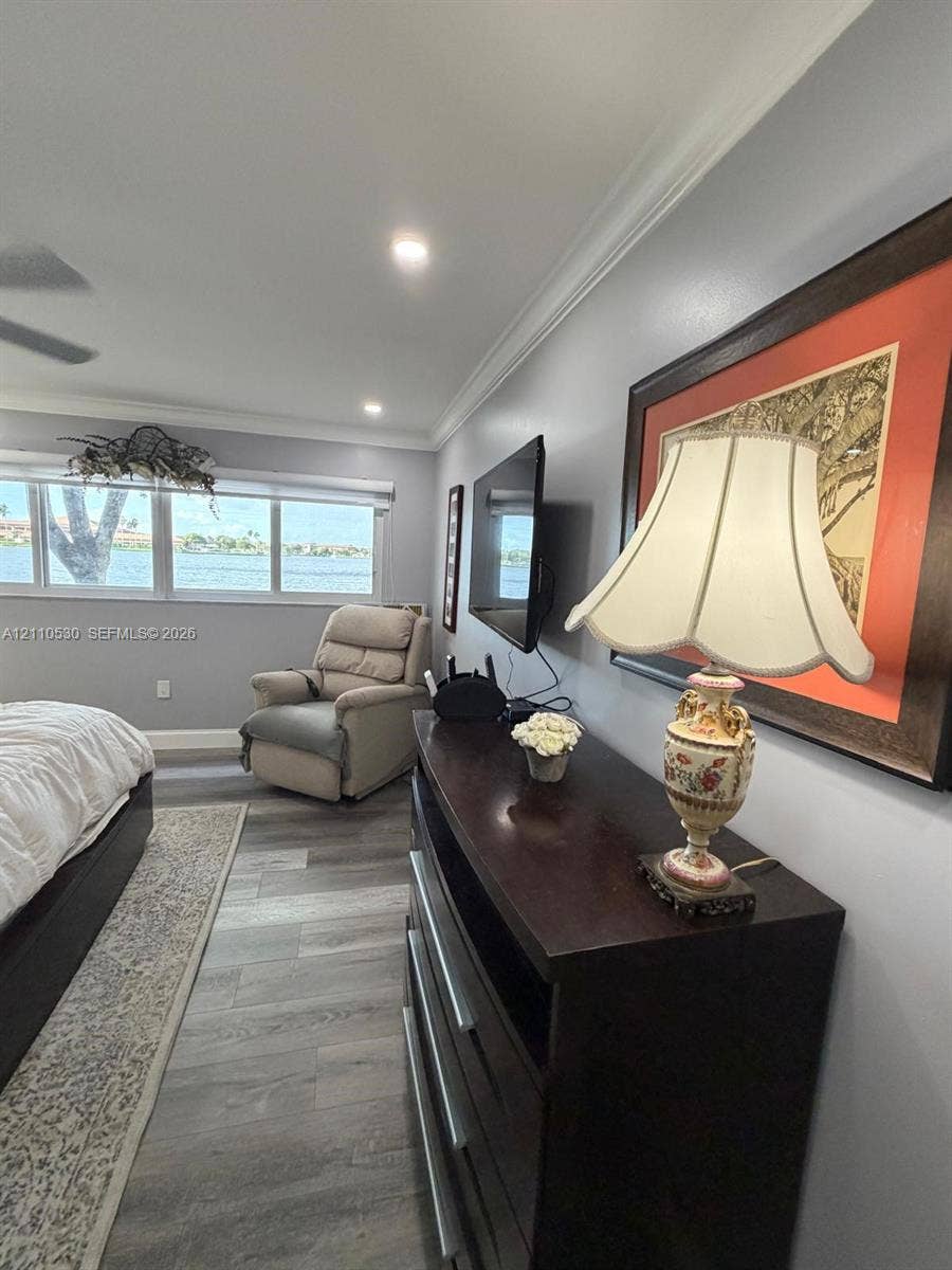 13255 SW 16th Court, #K112, Pembroke Pines, FL 33027 Interior space featuring wood-finish flooring, crown molding, recessed lighting, and large windows with water exposure