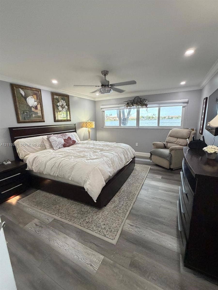 13255 SW 16th Court, #K112, Pembroke Pines, FL 33027 Wood-finish flooring, recessed ceiling lighting, a multi-blade ceiling fan, and large windows with water scenery