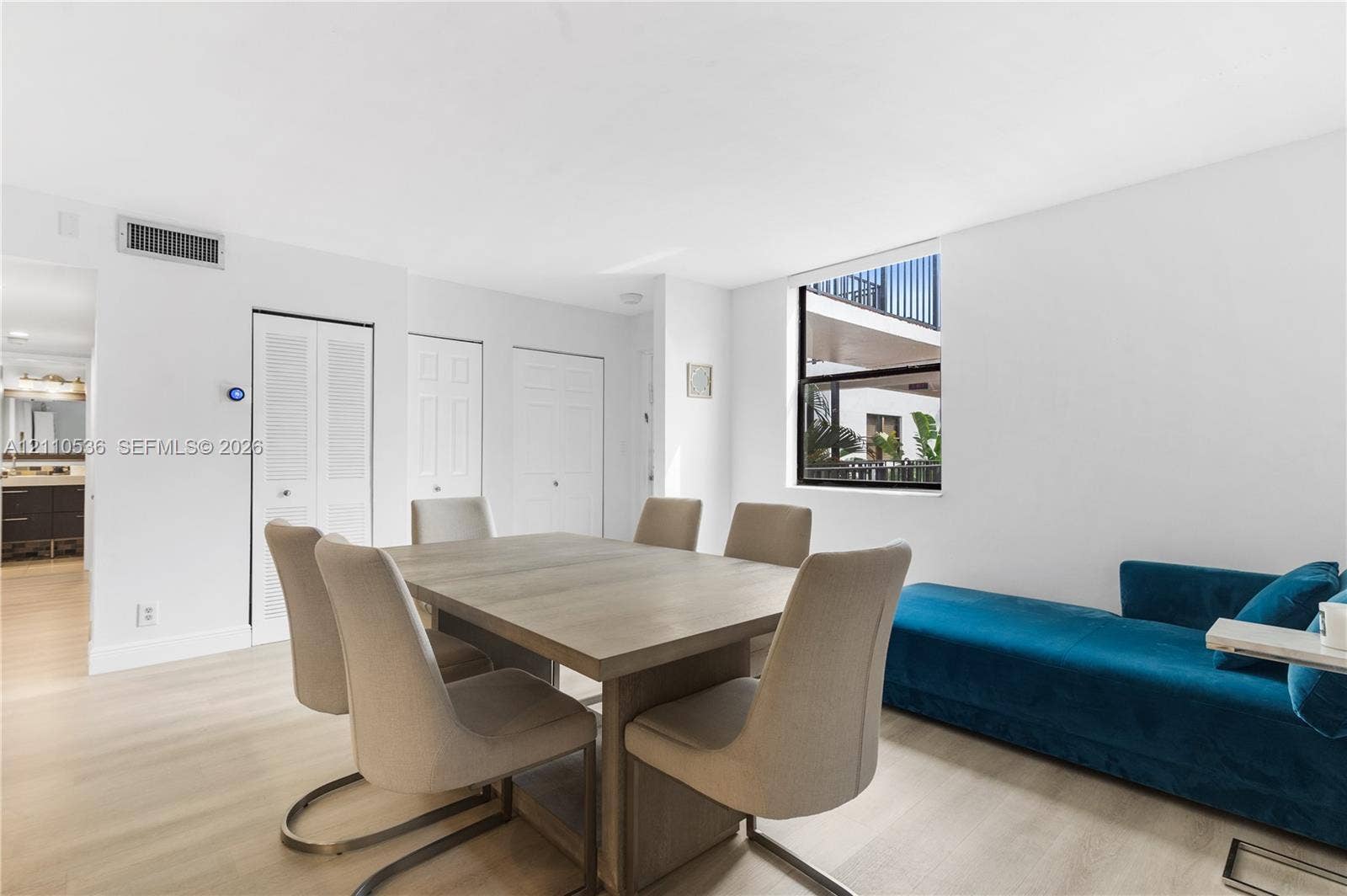 Neutral interior featuring light wood-finish flooring, recessed lighting, and a square window