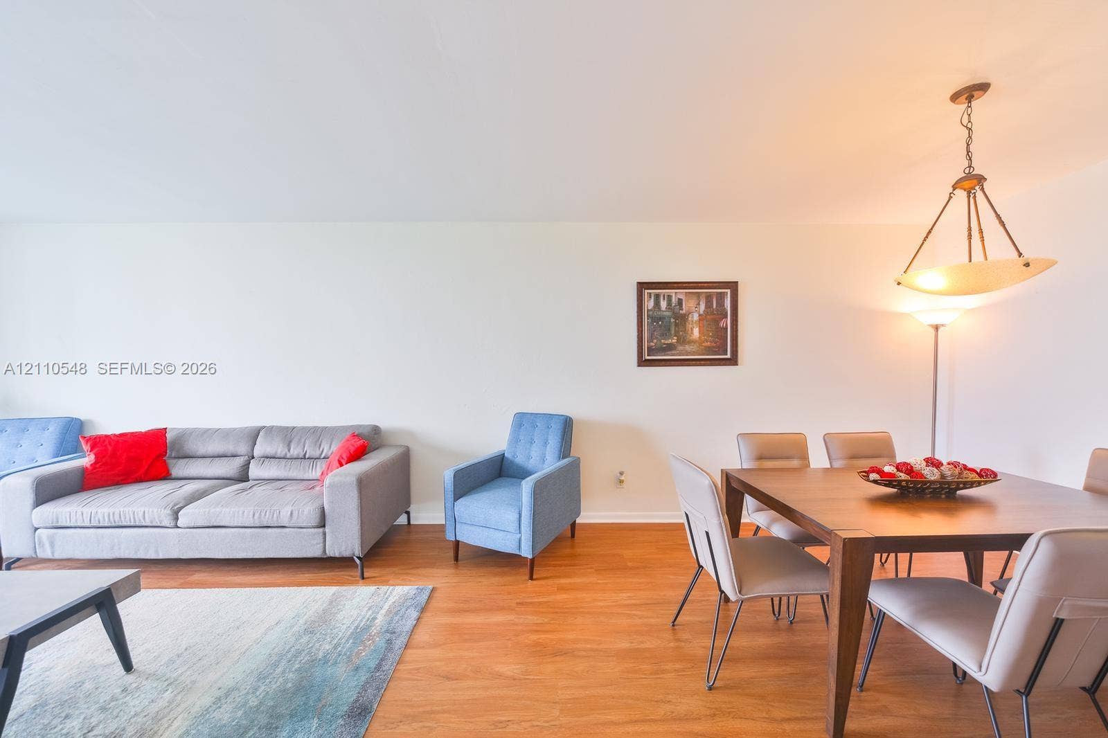 Open-concept area featuring wood-finish flooring and a suspended bowl-style chandelier