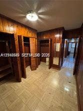 500 SW 39th Court, Miami, FL 33134 Wood-paneled walls, tile flooring, built-in storage closets, and a flush-mount ceiling light fixture
