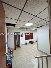 500 SW 39th Court, Miami, FL 33134 Interior space featuring grid-pattern acoustic drop ceiling tiles, integrated recessed lighting, and light-toned ceramic tile flooring