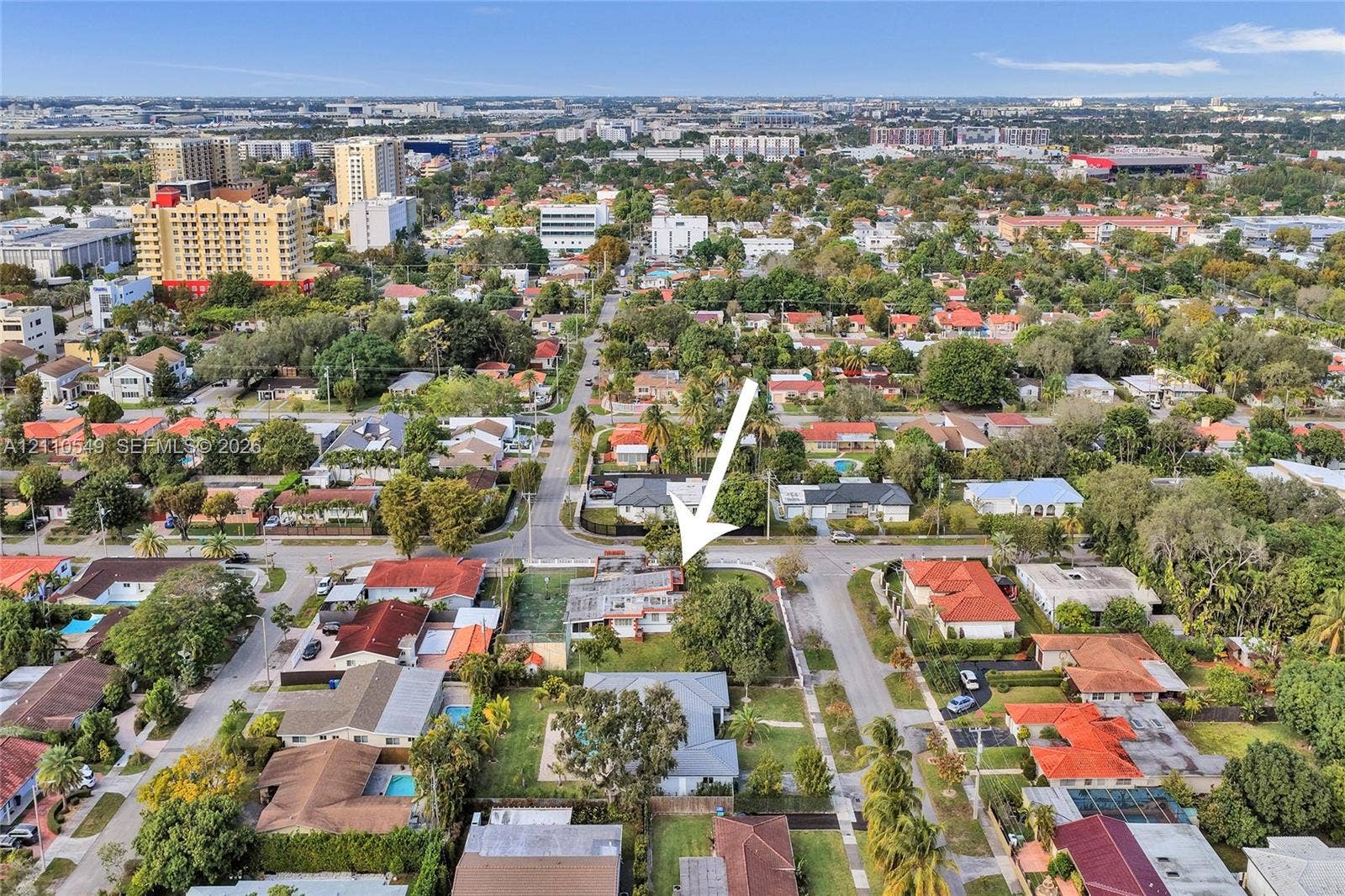 500 SW 39th Court, Miami, FL 33134 Aerial perspective of a corner lot property featuring a rectangular-shaped structure, perimeter fencing, and mature trees