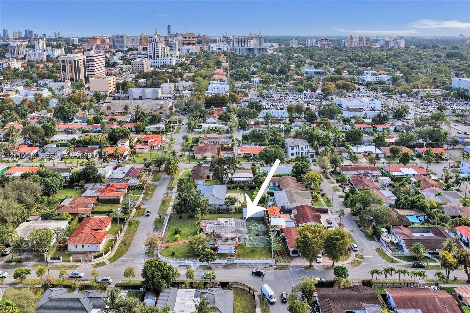 500 SW 39th Court, Miami, FL 33134 Aerial perspective of a corner lot featuring a residential structure, expansive lawn, mature landscaping, and a fenced perimeter
